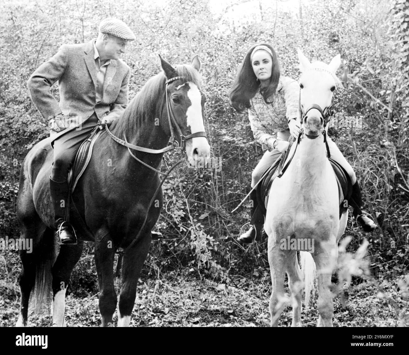 Roma, Italia: Cavalca un cavallo bianco .... Un Lipizzaner Stallion della famosa scuola di equitazione di Vienna. Le riprese a Roma in "riflessioni in un occhio d'oro" sono l'attrice Elizabeth Taylor, vista qui con l'attore Brian Keith, che appare anche nel film. Il ruolo di suo marito è Marlon Brando, che ha selezionato personalmente. 20 dicembre 1966 Foto Stock