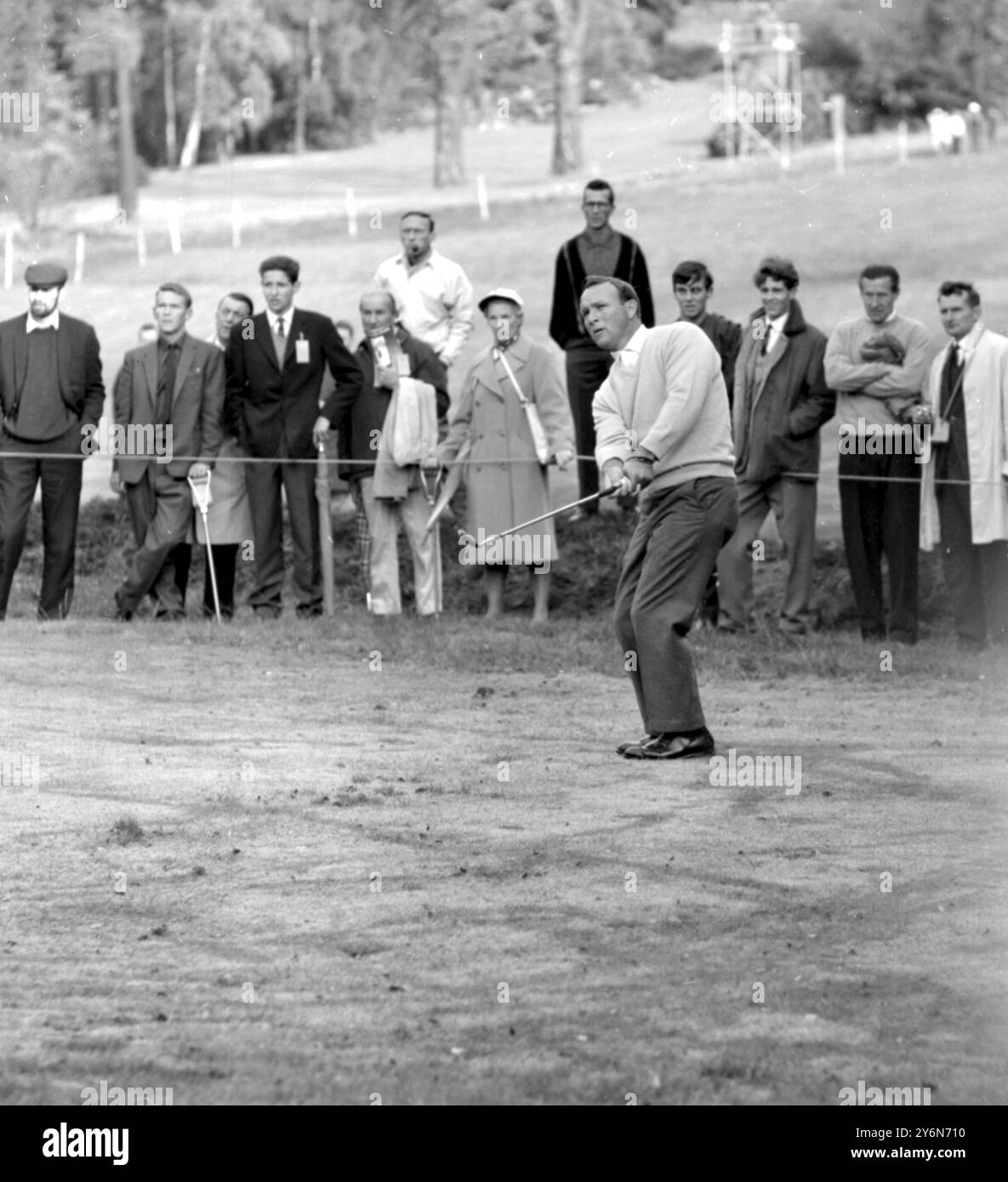 Virginia Water, Inghilterra: Arnold Palmer, degli Stati Uniti, lancia un tiro sul quarto green durante il primo giorno di gioco al Wentworth Golf Club, qui oggi, del torneo Piccadilly World Match Play. Palmer ha fatto coppia con l'inglese Peter Butler per le partite del primo turno con oltre 36 buche. 9 ottobre 1964 Foto Stock