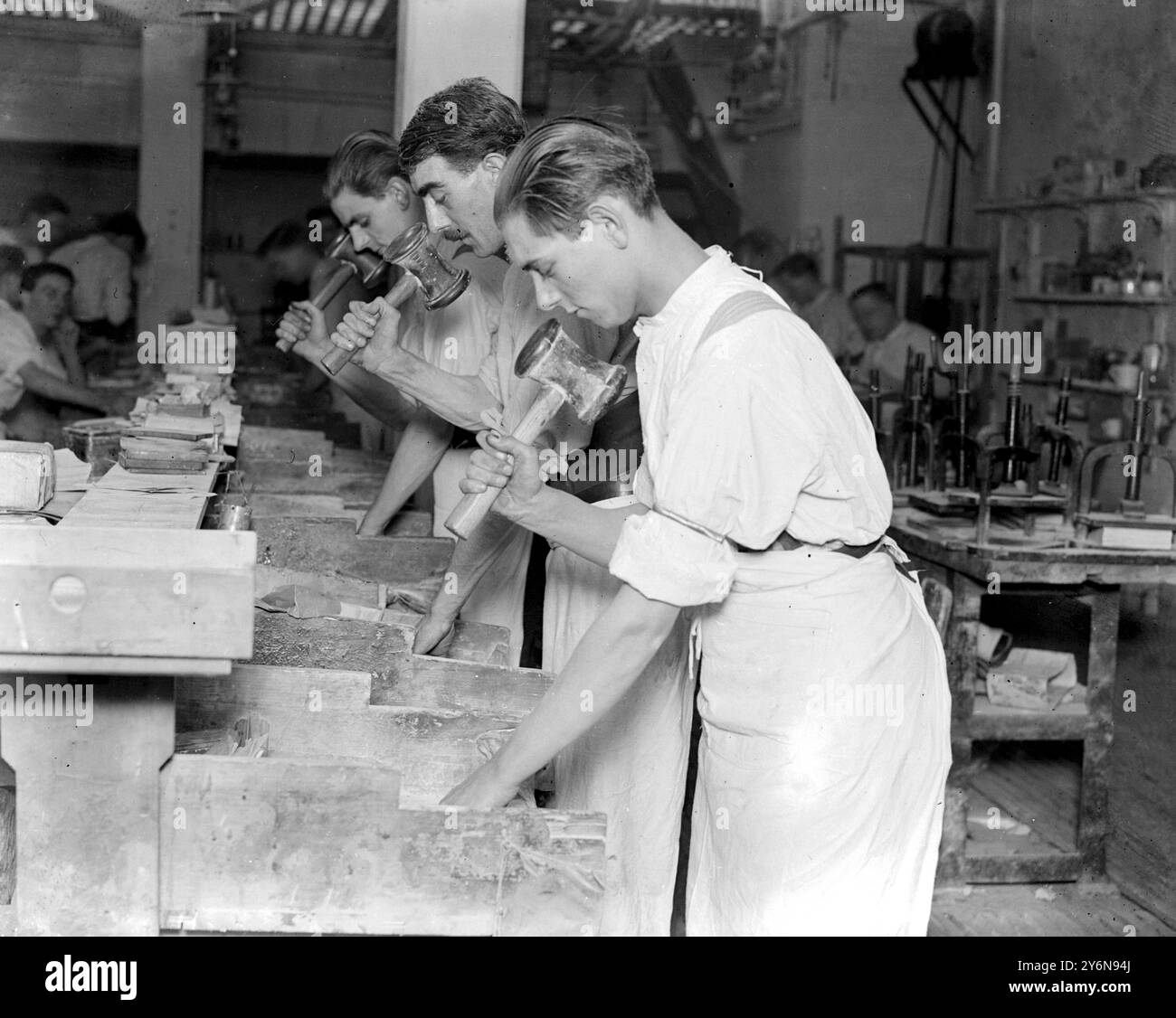 Battendo la foglia d'oro. L'arte di battere la foglia d'oro finissima esisteva 4.000 anni fa e molti dei tesori di luxor sono decorati con magnifici esemplari dell'artigianato. Oggi l'arte della battitura delle foglie d'oro è portata alla perfezione dai signori G.M. Whiley, Whitfield St, Tottenham CT RD, che da anni portano avanti l'attività. Battere con martelli da 12 libbre. 29 gennaio 1923 Foto Stock