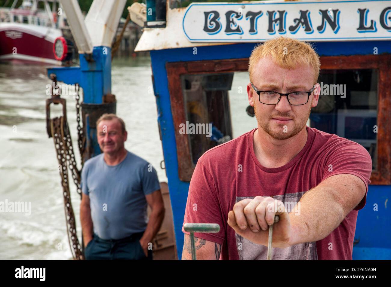 Il ventiquattrenne Shane Ball ha fatto lo skipper della barca da pesca per la famiglia fuori dal porto di Rye, mentre suo padre Robert (59) guarda avanti con orgoglio, agosto 2017. Shane e Robert sono in mare per oltre 12 ore, catturando principalmente dover Sole, passera di mare, sbiancamenti e dabb. Foto Stock