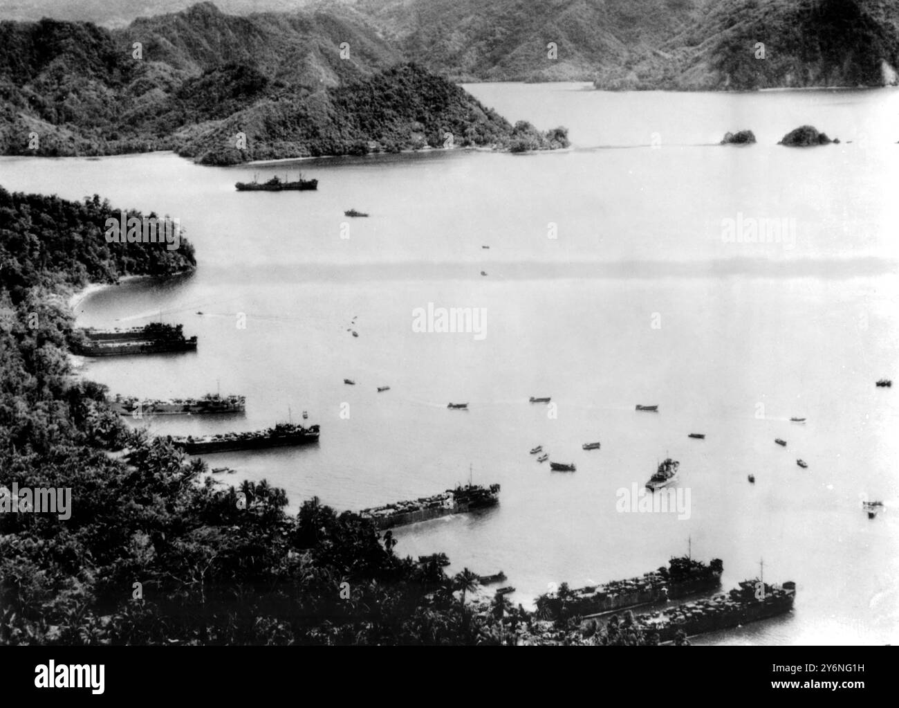 L'assalto STATUNITENSE è stato clandestino a Tanahmera Bay i vascelli americani LST (nave da sbarco-carro armato) (a sinistra) disgorgano le truppe e le attrezzature da guerra sulla spiaggia di Tanahmera Bay, mentre i mezzi da sbarco più piccoli manovravano al largo, il 22 aprile 1944. Tre sbarchi simultanei sulla costa settentrionale della nuova Guinea, eseguiti a Tanahmera Bay, nelle vicine Hollandia e Aitape, ad est, portarono altri 150 miglia di costa sotto il controllo degli Alleati. Due ulteriori sbarchi sei giorni dopo rafforzarono la trappola alleata intorno a circa 60.000 soldati nemici dispersi in tutta l'area costiera settentrionale del PAC sud-occidentale Foto Stock