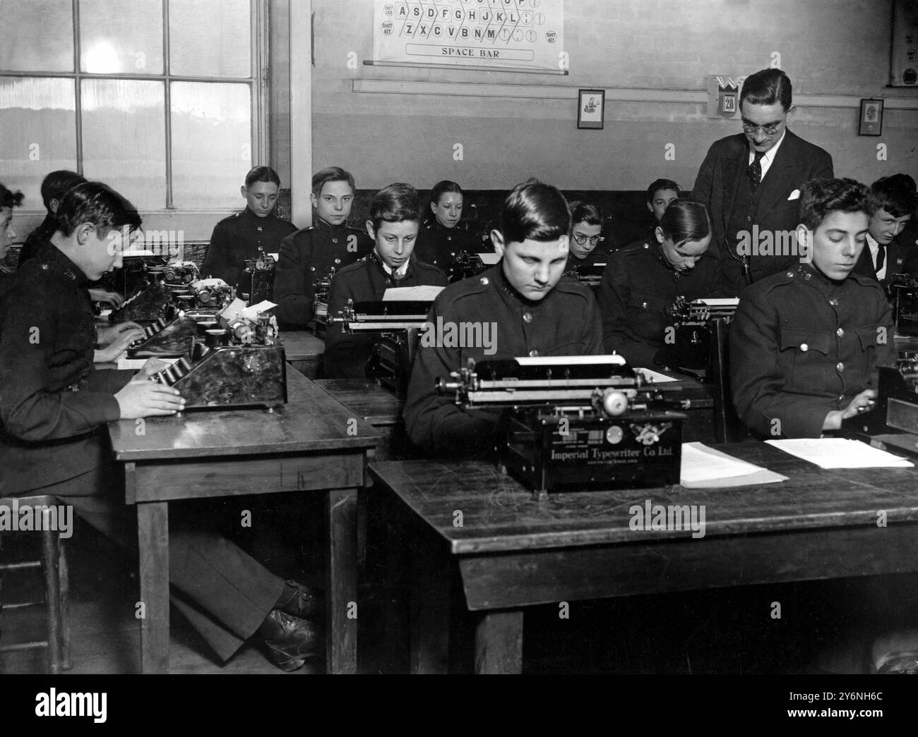 Ragazzi messaggeri in una classe di scrittura di caratteri al Kingsway Institute del London County Council sotto la direzione del signor T Gilbert. I ragazzi sono impiegati come messaggeri da compagnie via cavo che sono tra i più grandi datori di lavoro del lavoro maschile. Frequentano le lezioni per 6 ore a settimana per essere preparati al momento in cui la loro età richiederà la loro uscita dal lavoro attuale. 27 gennaio 1935 Foto Stock