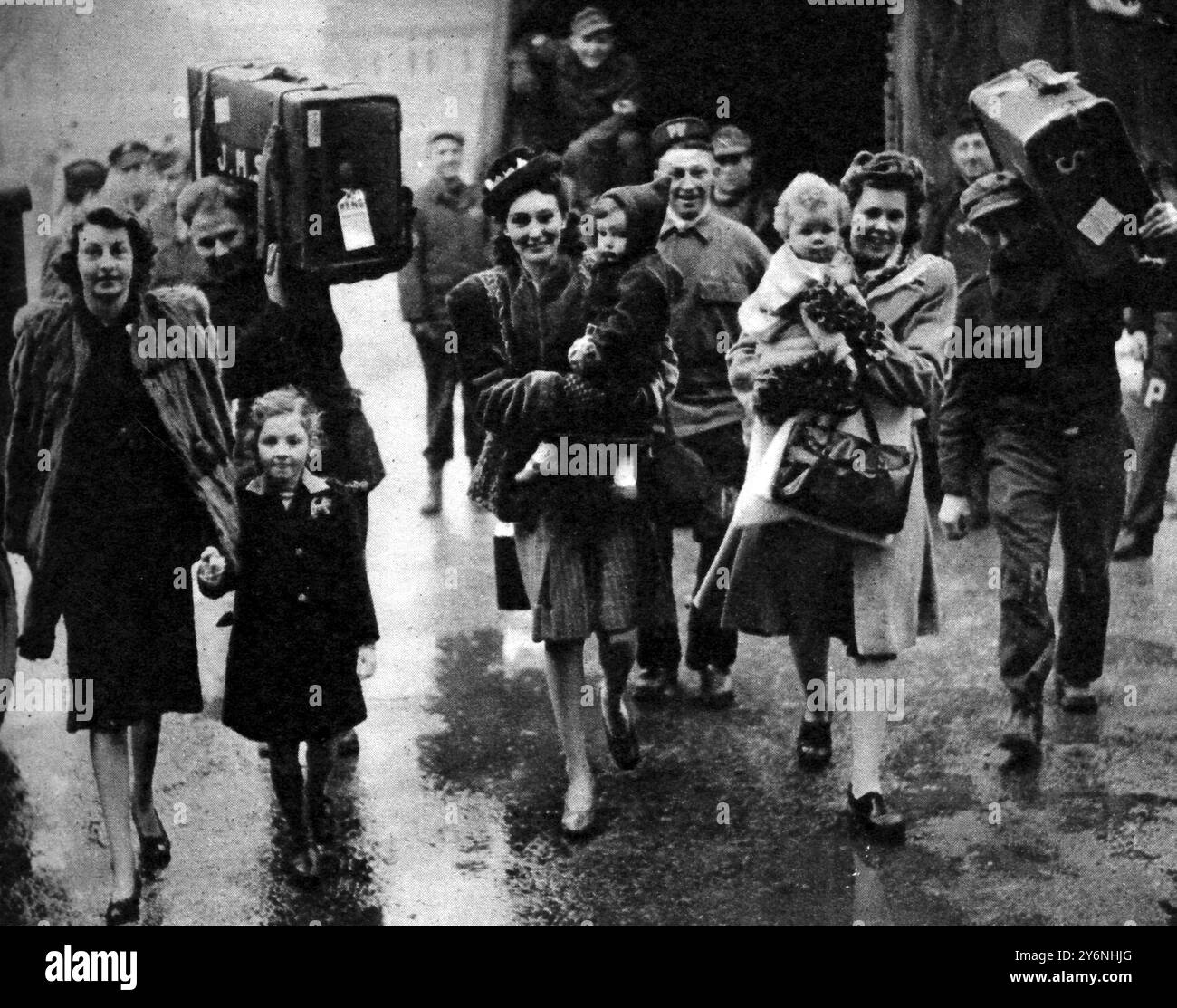 Spose gi in viaggio per le spose gi statunitensi che arrivano al campo di transito di Perham Down, con prigionieri di guerra tedeschi per trasportare i loro bagagli. Febbraio 1946 Foto Stock