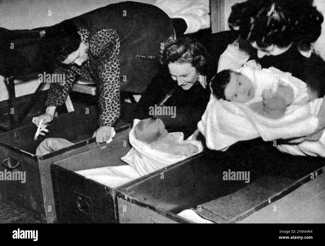 Le spose gi sono in viaggio per le spose gi statunitensi che mettono i loro bambini a dormire nei cassetti dell'armadio per le notti di riposo nel campo di transito. Febbraio 1946 Foto Stock