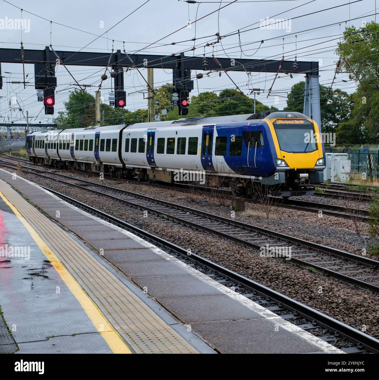 L'elegante treno passeggeri accelera lungo i binari, mostrando l'efficienza dei trasporti pubblici. Foto Stock