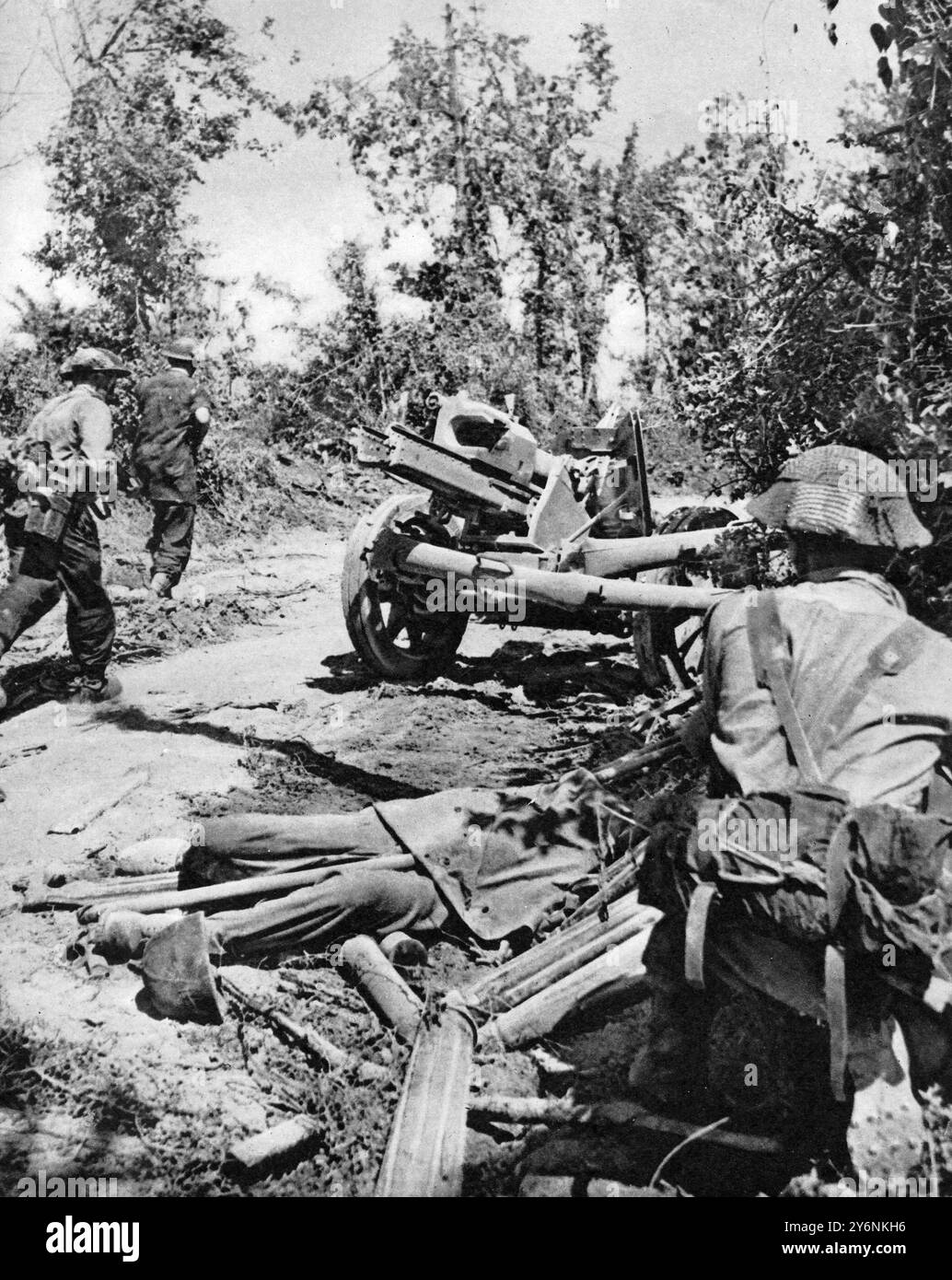 Le prime fasi della grande avanzata alleata in Italia, scene di battaglia dall'area della Valle del Liri. Una scena sul fronte di battaglia dell'Ottava Armata, gli uomini di un plotone che avanzano in azione passano davanti a un cannone anticarro da 75 mm abbandonato accanto al quale si trova uno dei cannoni tedeschi morti. Giugno 1944 Foto Stock