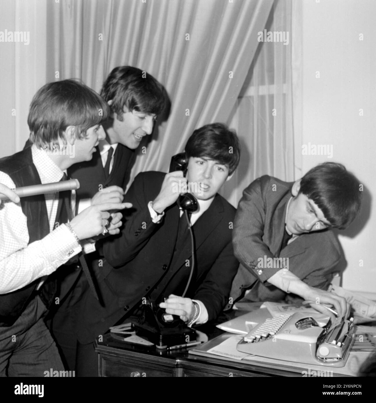 New York: Beseiges dei fan al Plaza Hotel qui, i Beatles trovano che il telefono è il collegamento più sicuro con il mondo esterno. I quattro Merseyside Lads, (sinistra-destra) Ringo Starr, John Lennon, Paul McCartney e George Harrison, sono ritratti nella loro camera d'albergo il sabato. Più tardi McCartney, Lennon e Starr riuscirono a sfuggire ai fan e a trascorrere un po' di tempo visitando Central Park. George è stato confinato a letto con una gola fredda e dolorante, ma è riuscito a recuperare abbastanza per apparire all'ed Sullivan T.V. Show ieri sera. 10 febbraio 1964 Foto Stock