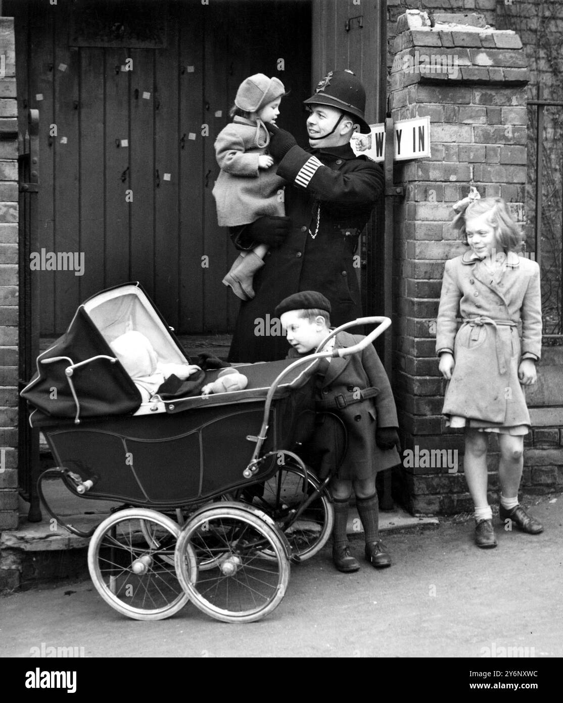 Elezioni generali del 1950. Giorno dei sondaggi, 23 febbraio Agente in servizio presso una stazione elettorale di Wandsworth, nel sud di Londra, si prende cura dei bambini mentre le loro madri votano. Foto Stock