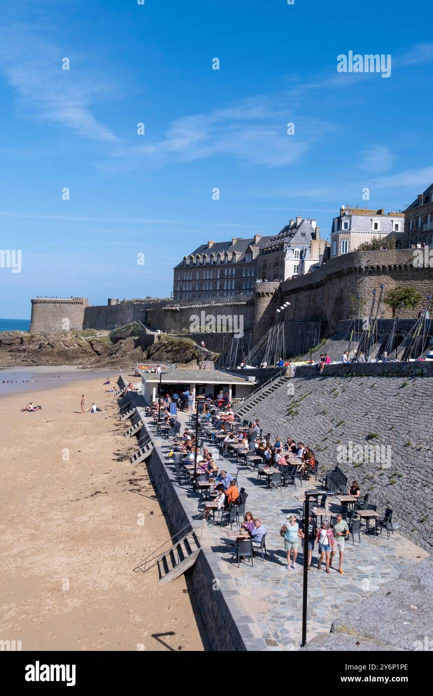 Saint-Malo (Bretagna, Francia nord-occidentale): Gente che gode il sole sulla terrazza di un caffè lungo la spiaggia "plage de Bon Secours". Vista della rampa Foto Stock