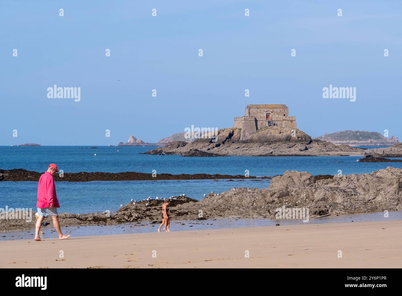 SaintMalo (Bretagna, Francia nord-occidentale): forte dell'isola delle maree "Petit Bé" visto dalla spiaggia "plage du Môle" e camminatori sulla spiaggia Foto Stock