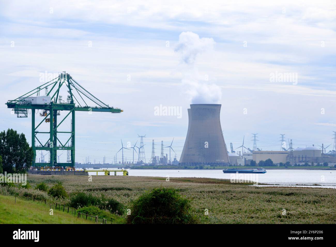 Belgio, Anversa: La centrale nucleare di Doel sulle rive del fiume Schelda e la gru portuale nel porto commerciale Foto Stock