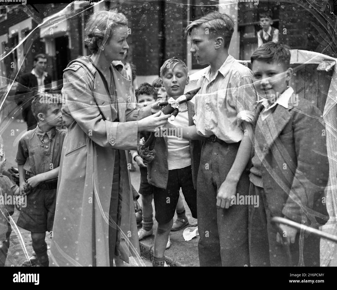 I bambini di Mitre St , Waterloo , Londra , decisero che una piacevole aggiunta alla strada sarebbe stata uno spettacolo di Punch and Judy proprio , che facevano con pezzi di materiale di scarto e scatole arancioni . I cinque bambini che hanno creato e organizzato lo spettacolo sono Fred Wilson , Will Webb , che fa anche commenti , Dave Eason , Raymond Jordan e Will Bridges . L'immagine mostra Ursula Jeans , star del palco e dello schermo tra il pubblico infantile dello spettacolo Punch and Judy . 11 agosto 1950 Foto Stock