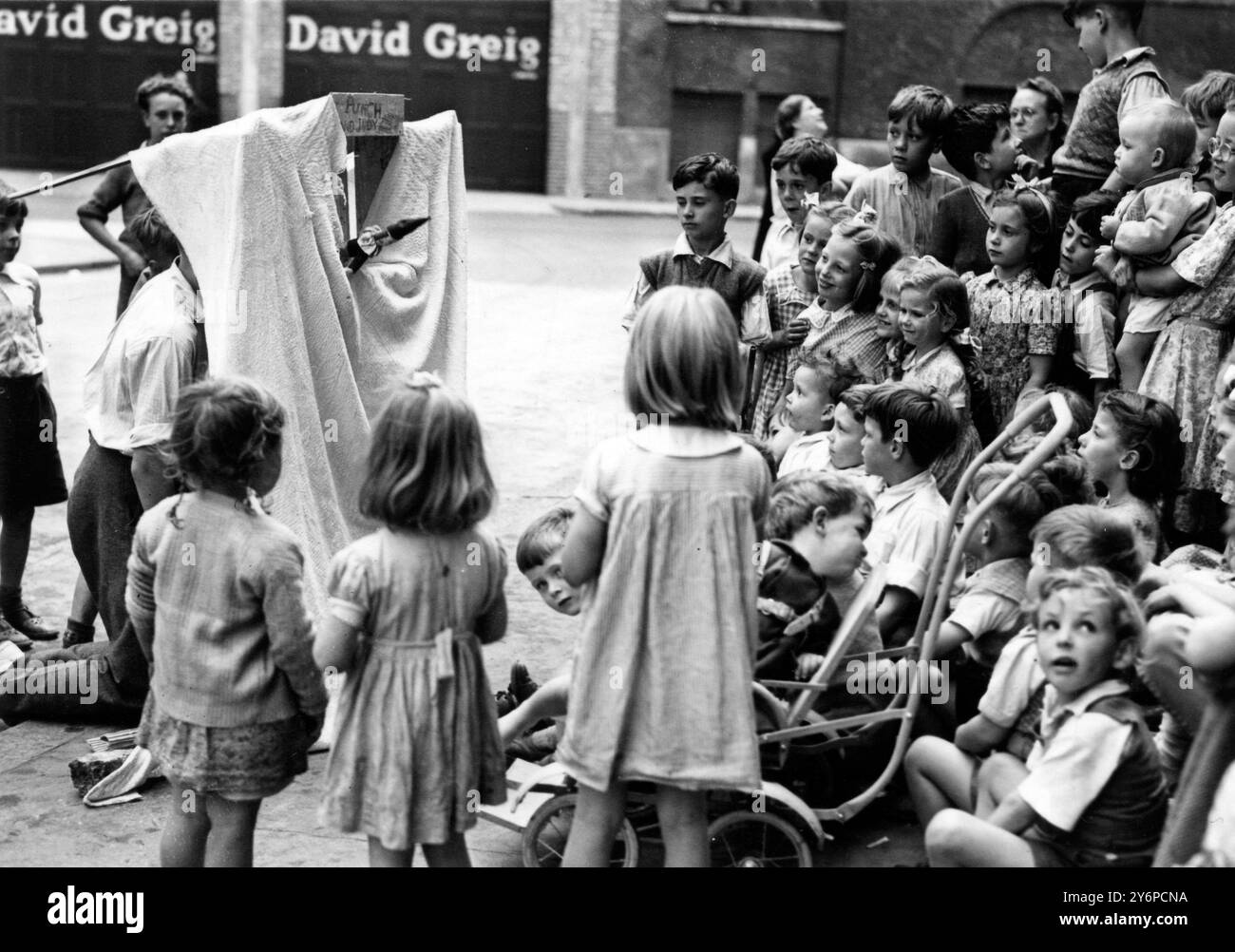 I bambini di Mitre St , Waterloo , Londra , decisero che una piacevole aggiunta alla strada sarebbe stata uno spettacolo di Punch and Judy proprio , che facevano con pezzi di materiale di scarto e scatole arancioni . I cinque bambini che hanno creato e organizzato lo spettacolo sono Fred Wilson , Will Webb , che fa anche commenti , Dave Eason , Raymond Jordan e Will Bridges . L'immagine mostra il pubblico infantile dello spettacolo Punch and Judy . 11 agosto 1950 Foto Stock