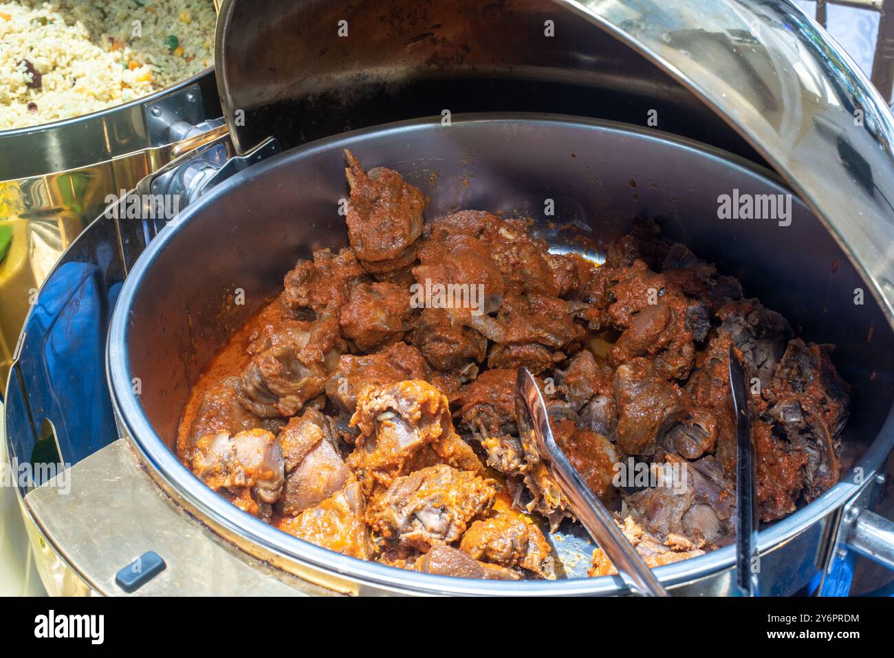 Pollo grigliato mescolato con stufato per gli ospiti a una festa di compleanno a Lagos Foto Stock