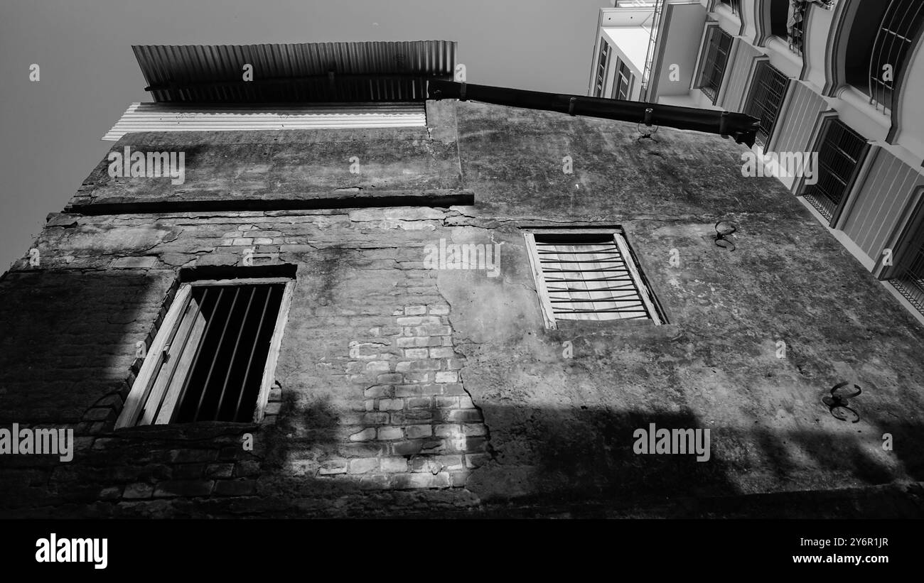 Immagine in bianco e nero di una vecchia casa. Gioco di luce sul vecchio muro. Howrah, Bengala Occidentale, India. Foto Stock