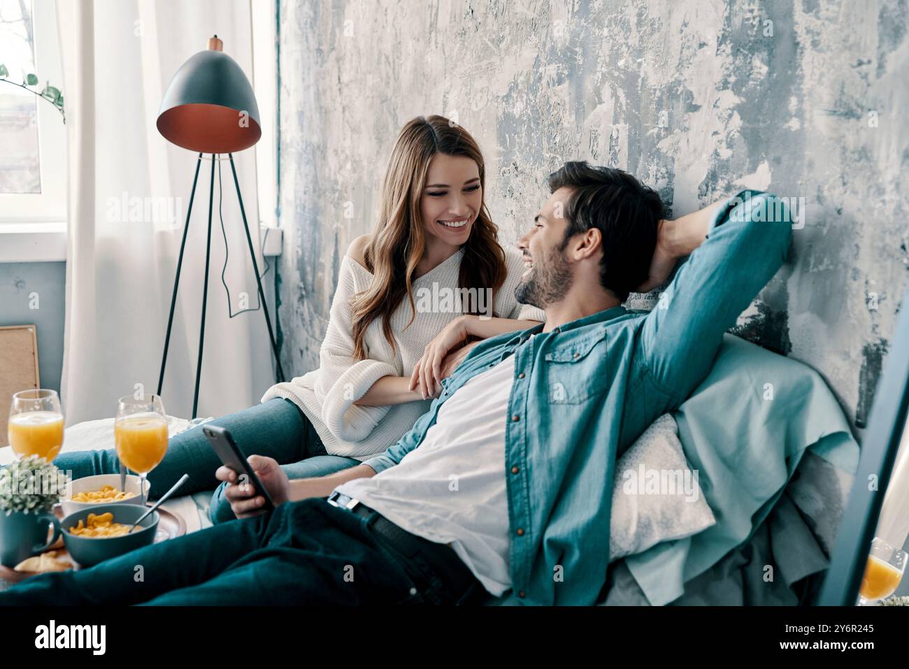 Non importa. Una bella giovane coppia che fa colazione mentre passava del tempo a letto a casa Foto Stock