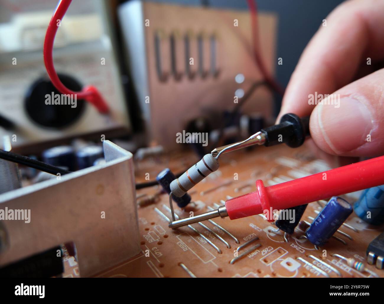 Test tecnici - misurazione dei componenti elettronici sulla scheda a circuiti stampati. Focalizzato sul resistore. Foto Stock