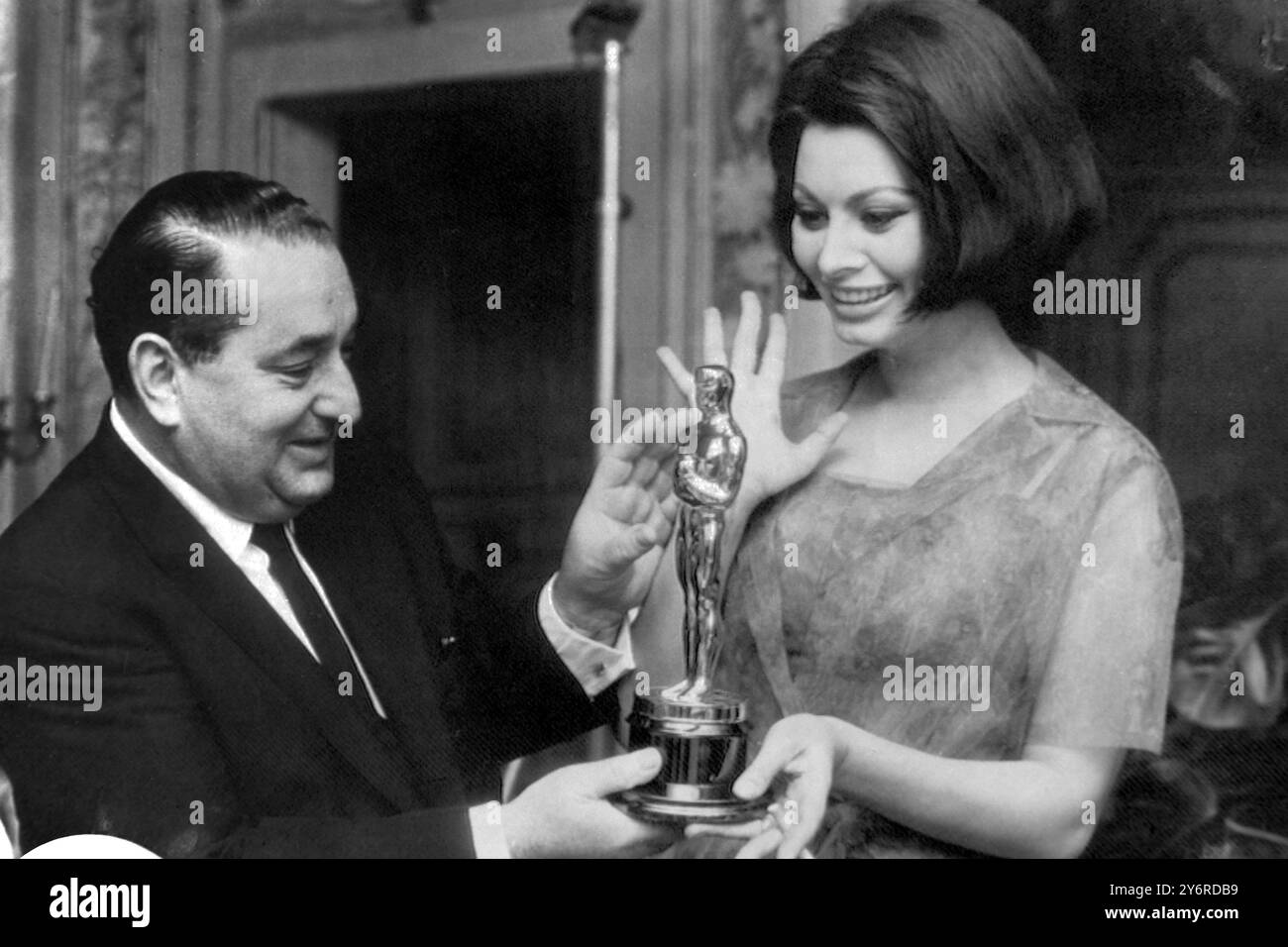 IL 15 APRILE 1962 IL PRODUTTORE CINEMATOGRAFICO JOSEPH LEVINE PRESENTA UN OSCAR ALLA VINCITRICE DEL PREMIO OSCAR SOPHIA LOREN NEL SUO APPARTAMENTO A ROMA, IN ITALIA, PER IL SUO MIGLIOR RUOLO DI ATTRICE PER "DUE DONNE". LOREN NON FU IN GRADO DI PARTECIPARE ALLA CERIMONIA UFFICIALE NEGLI STATI UNITI. Foto Stock