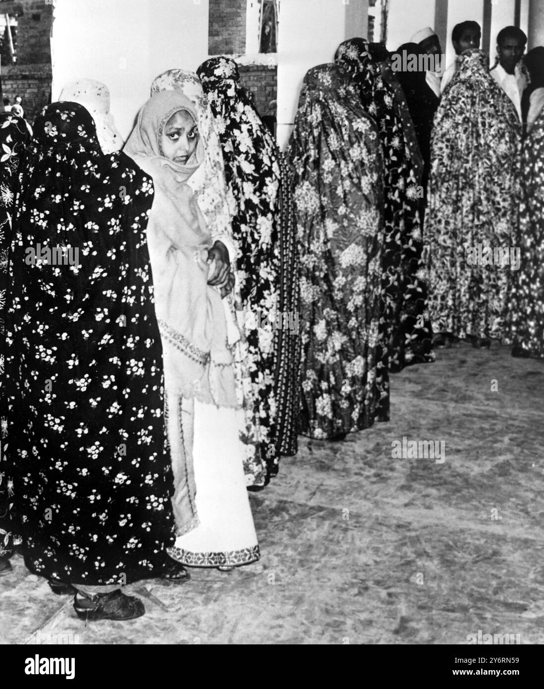 IL 27 FEBBRAIO 1962 LE DONNE HANNO VELATO E SVELATO NELLA LORO FILA BURQAS PER VOTARE ALLE ELEZIONI GENERALI IN INDIA PER LA TERZA VOLTA IN UNA TRIBUNA ELETTORALE A BENARES, IN INDIA. Foto Stock