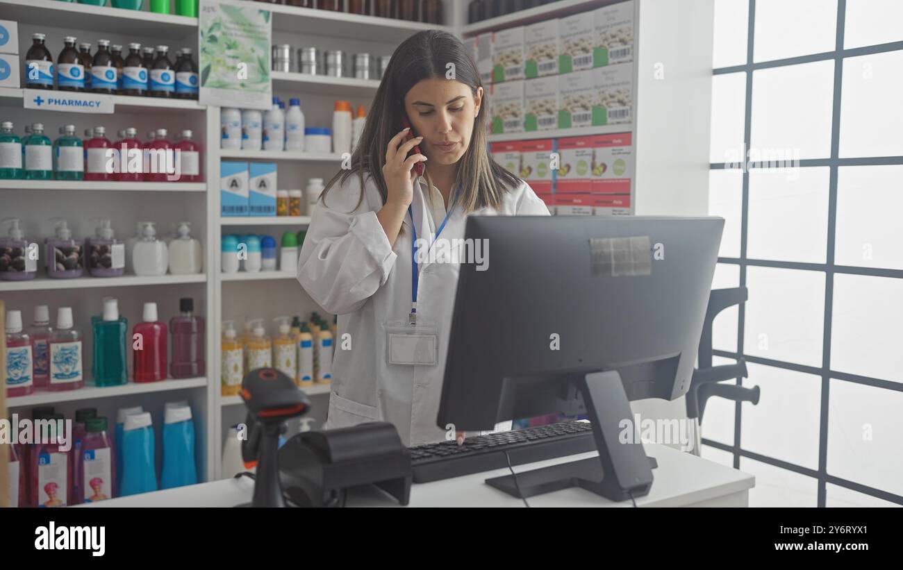 Una farmacista concentrata parla al telefono in una farmacia ben fornita con una varietà di prodotti sugli scaffali. Foto Stock