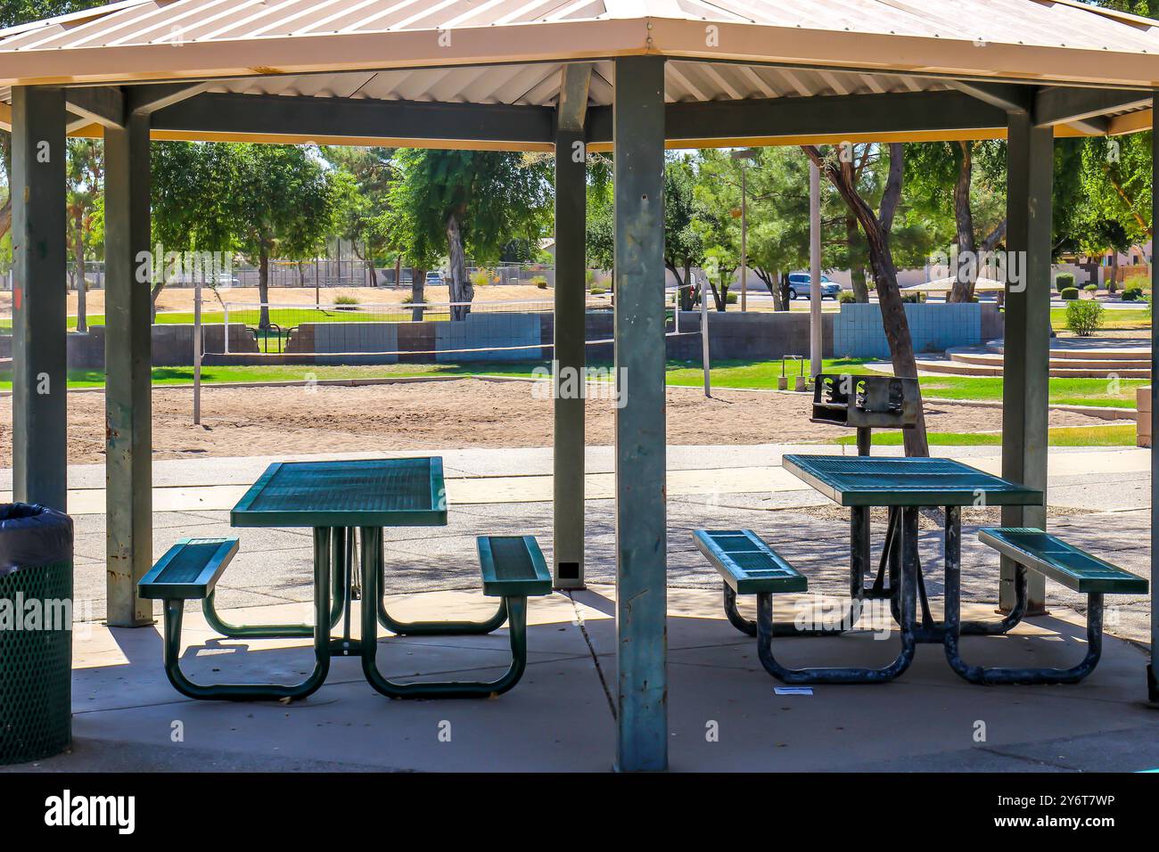 Tavoli da picnic coperti con panchine e barbecue al parco locale Foto Stock