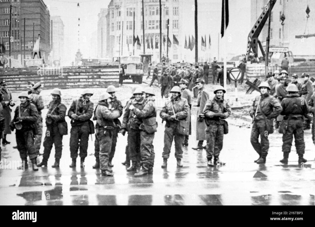 Le truppe della Germania Est, vestite in abiti da battaglia e armate di mitragliatrici, erano di stanza al posto di blocco di Friedrichstrasse tra Berlino Est e Berlino Ovest ieri sera, quando centinaia di polizia e truppe della Germania Est hanno iniziato a rafforzare il muro e a restringere l'ingresso delle auto a Berlino Est. Poco dopo che le truppe avevano iniziato il lavoro, le truppe degli Stati Uniti furono spostate per rinforzare la polizia militare al posto di blocco. 4 DICEMBRE 1961 Foto Stock