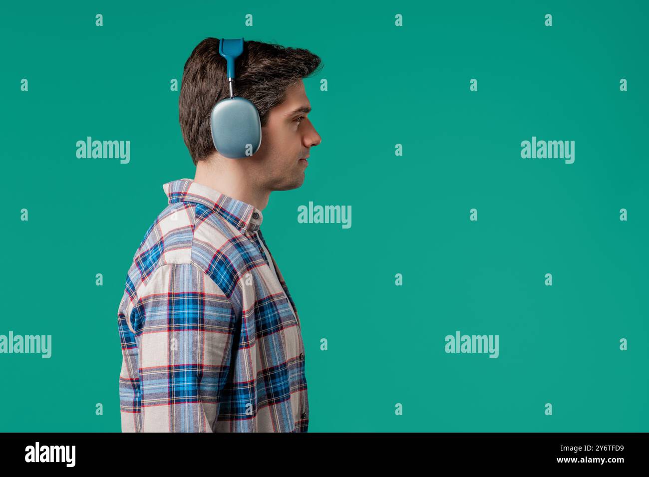 Uomo bello e positivo che ascolta musica, si diverte con le cuffie moderne, copia spazio Foto Stock