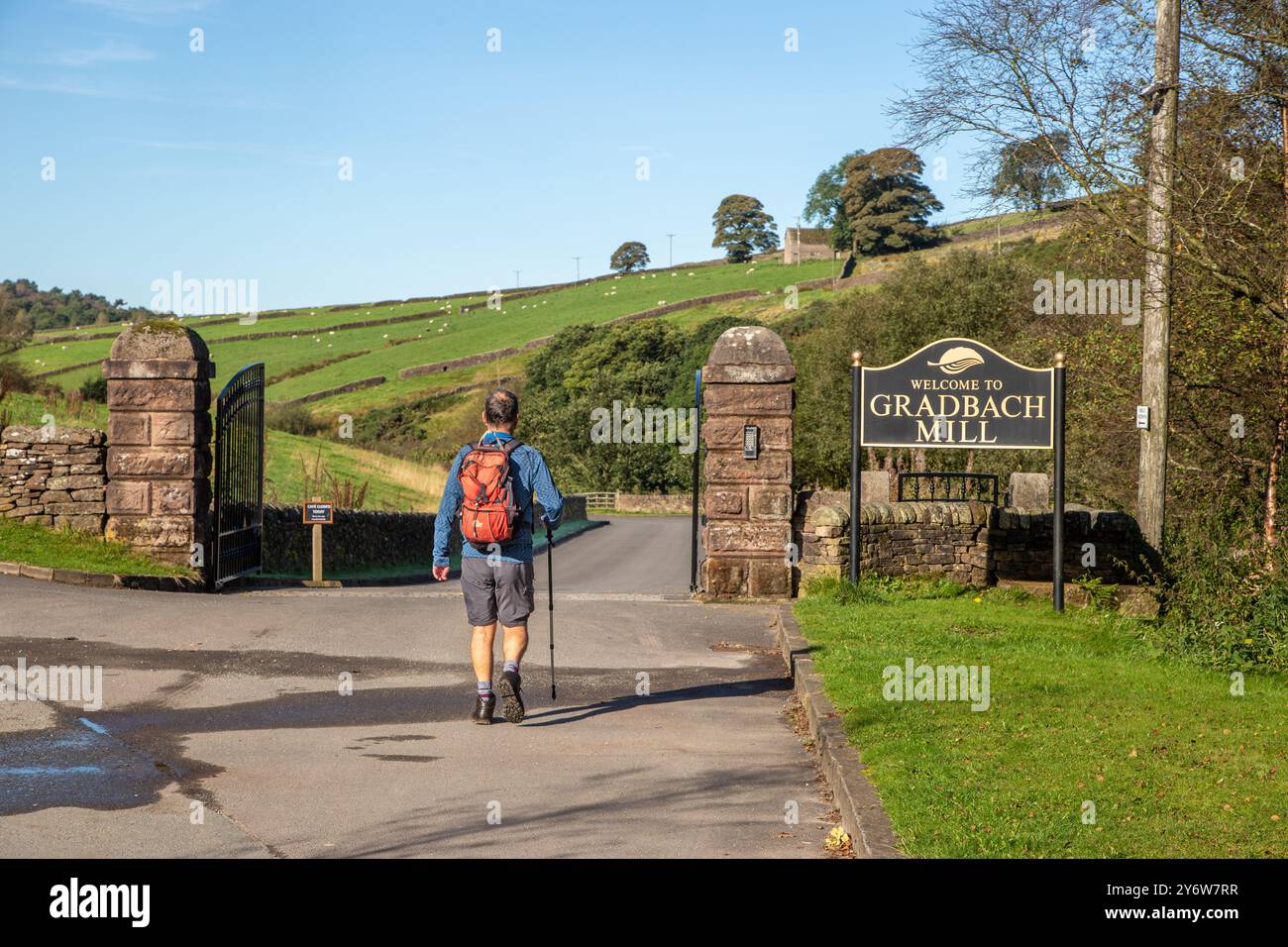 Uomo che cammina con zaino in spalla e cammina nei terreni del mulino Gradbach, nell'English Peak District Foto Stock