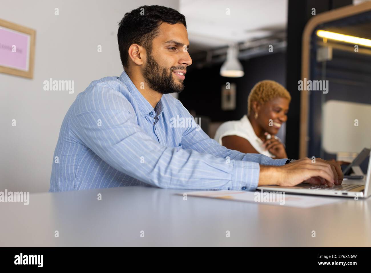 Collaborazione in un ufficio moderno, colleghi che lavorano su notebook Foto Stock