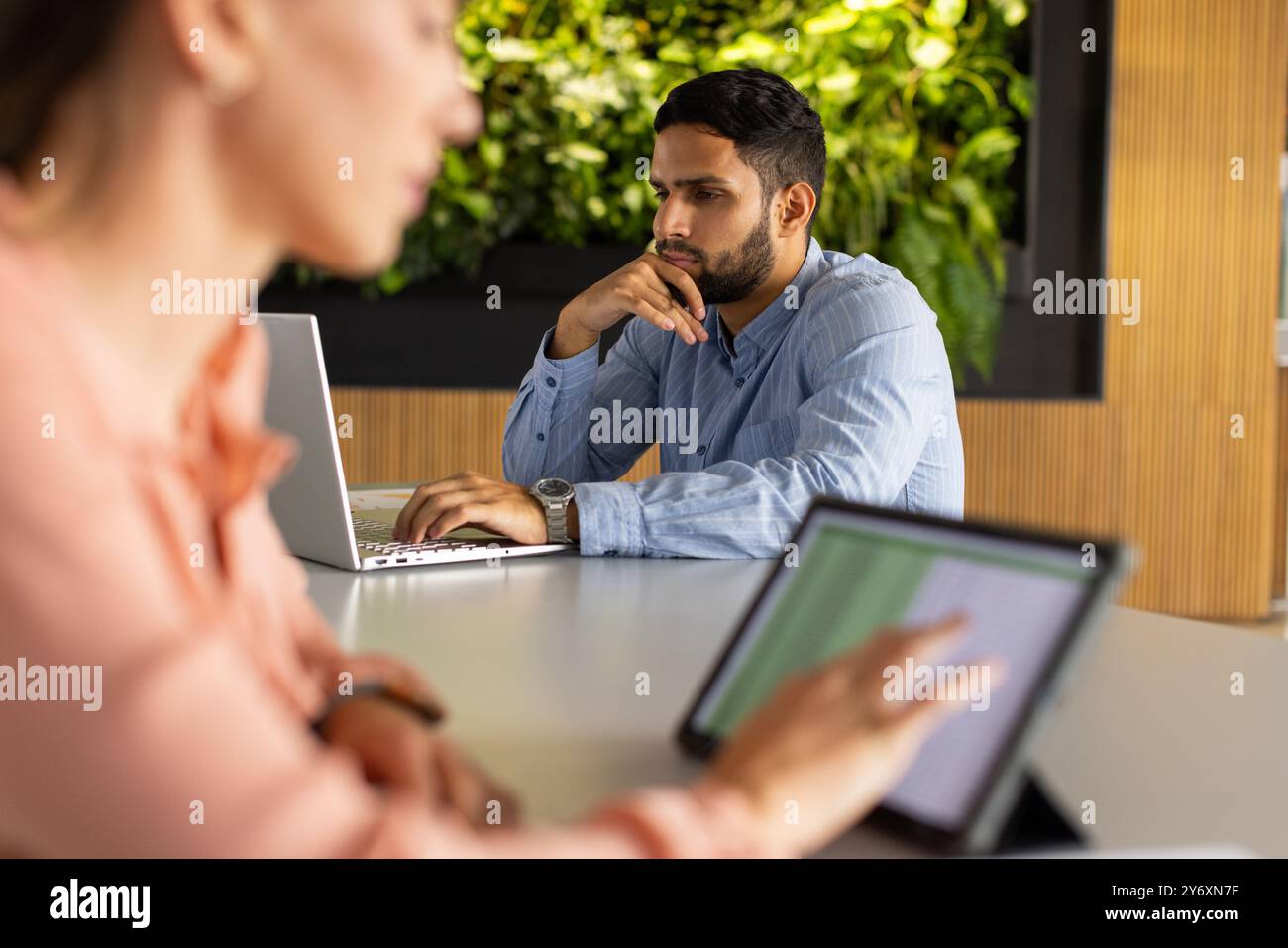 Collaborare in un ufficio moderno, colleghi che lavorano su notebook e tablet Foto Stock