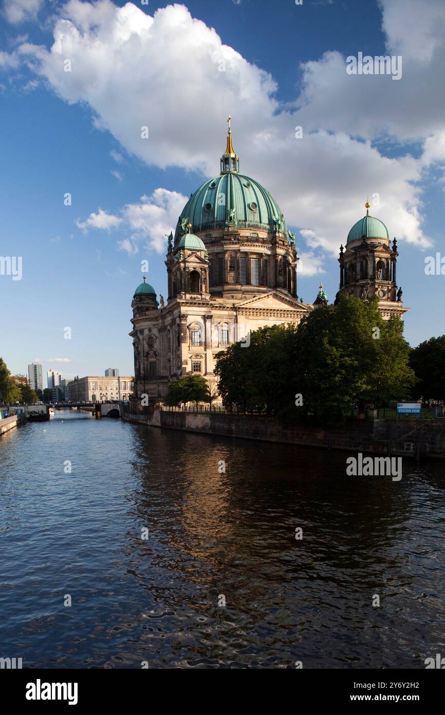 Il Berliner Dom sorge maestosamente lungo il fiume Sprea, mostrando la sua splendida architettura sotto un cielo azzurro. Foto Stock