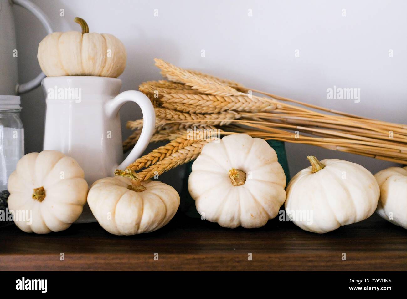 Zucche bianche piccole su legno rustico con grano naturale Foto Stock