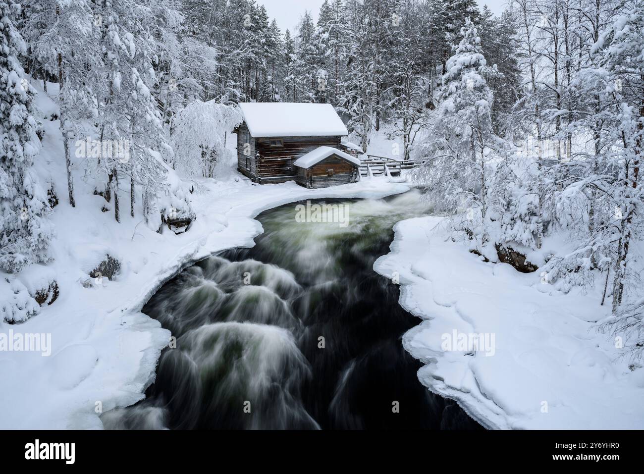 Vecchio mulino Myllykoski, coperto di neve in inverno, vicino alle rapide del fiume Kitkajoki nel Parco Nazionale di Oulanka (Juuma Kuusamo Lapponia Finlandia) Foto Stock