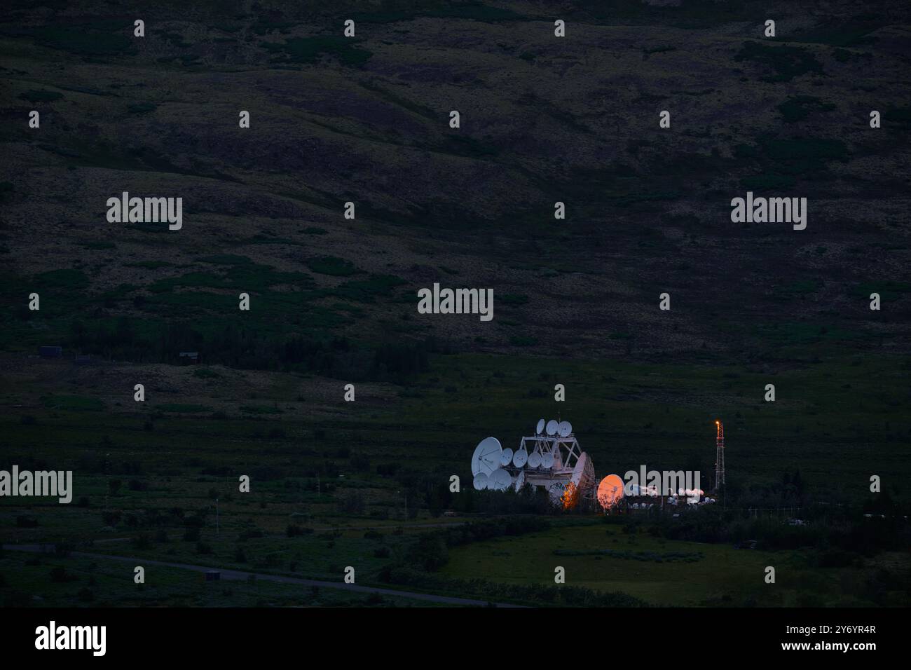 Complesso di parabole satellitari sulle montagne al buio Foto Stock