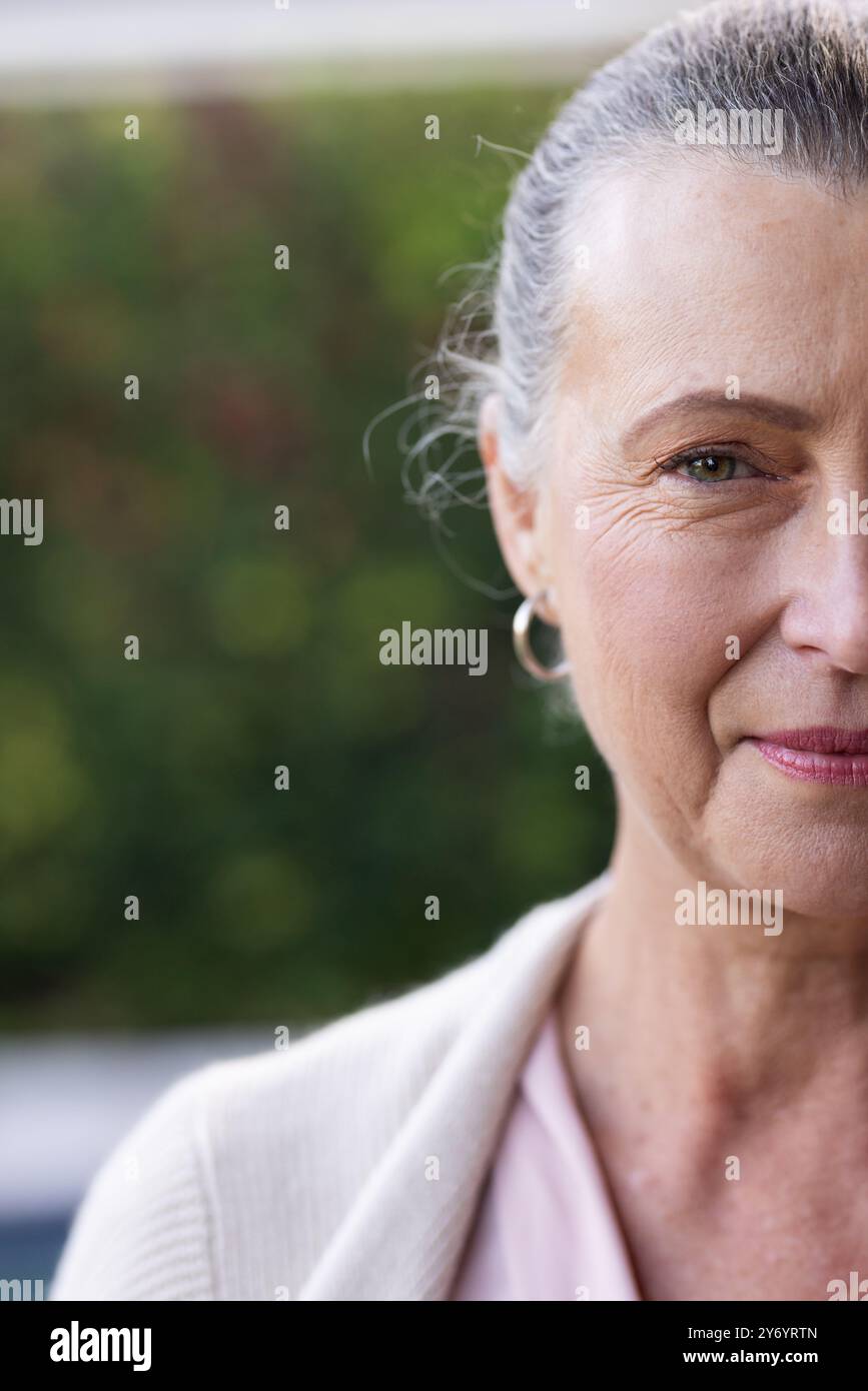 Donna anziana sorridente con orecchini a cerchio, ritratti ravvicinati all'esterno, spazio per le copie, a casa. all'aperto, gioielleria, felicità, espressione, stile di vita Foto Stock