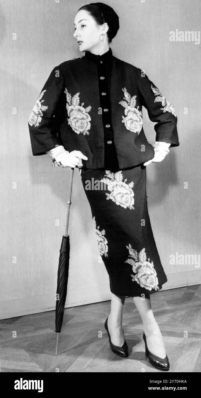 Prendendo spunto dal libro della nonna , la designer de Givenchy di Parigi produce questo elegante abito pomeridiano "arazzo" . E' in punta ad ago nera, decorata con rose completamente soffiate e foglie di verde brillante. La giacca in stile cardigan, lunga all'anca, è rifinita con velluto nero per abbinarsi al cappello toque. Agosto 1952 Foto Stock