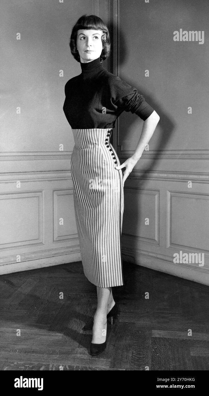 La linea Principessa è in evidenza in questa gonna Paneth in cognac bianco e a righe nere pettinate . I bottoni neri rotondi fissano il lato intrecciato nero . È indossato con un maglione nero. 8 dicembre 1953 Foto Stock