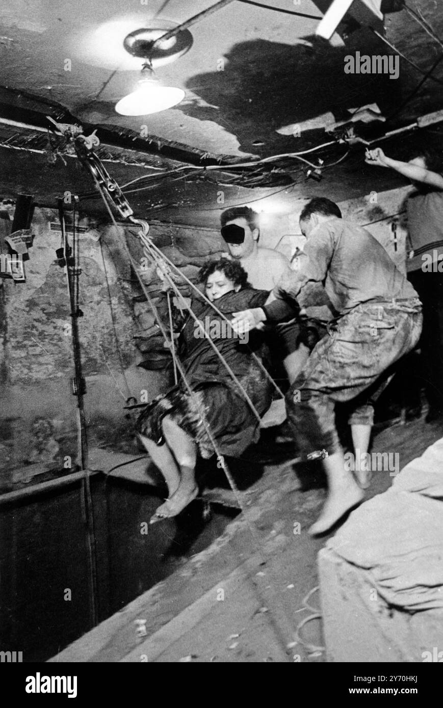 Una donna rifugiata della Germania Est viene portata in una cantina di Berlino Ovest da un tunnel attraverso il quale 57 tedeschi dell' Est , compresi i bambini , sono fuggiti a Berlino Ovest per un periodo di tre giorni a partire dal 3 ottobre 1964 . Il tunnel , che inizia a Berlino Est , passa sotto il muro di Berlino , termina in un seminterrato di una casa a Bernauer Strasse , Berlino Ovest . La fuga dal tunnel è stata tenuta così segreta che le autorità occidentali non ne sapevano nulla fino a quando le fughe non sono state completamente completate il 5 ottobre 1964 . Le autorità della Germania Est hanno scoperto il tunnel il 5 ottobre e hanno sparato pistole a macchina nel tunnel, ma no Foto Stock