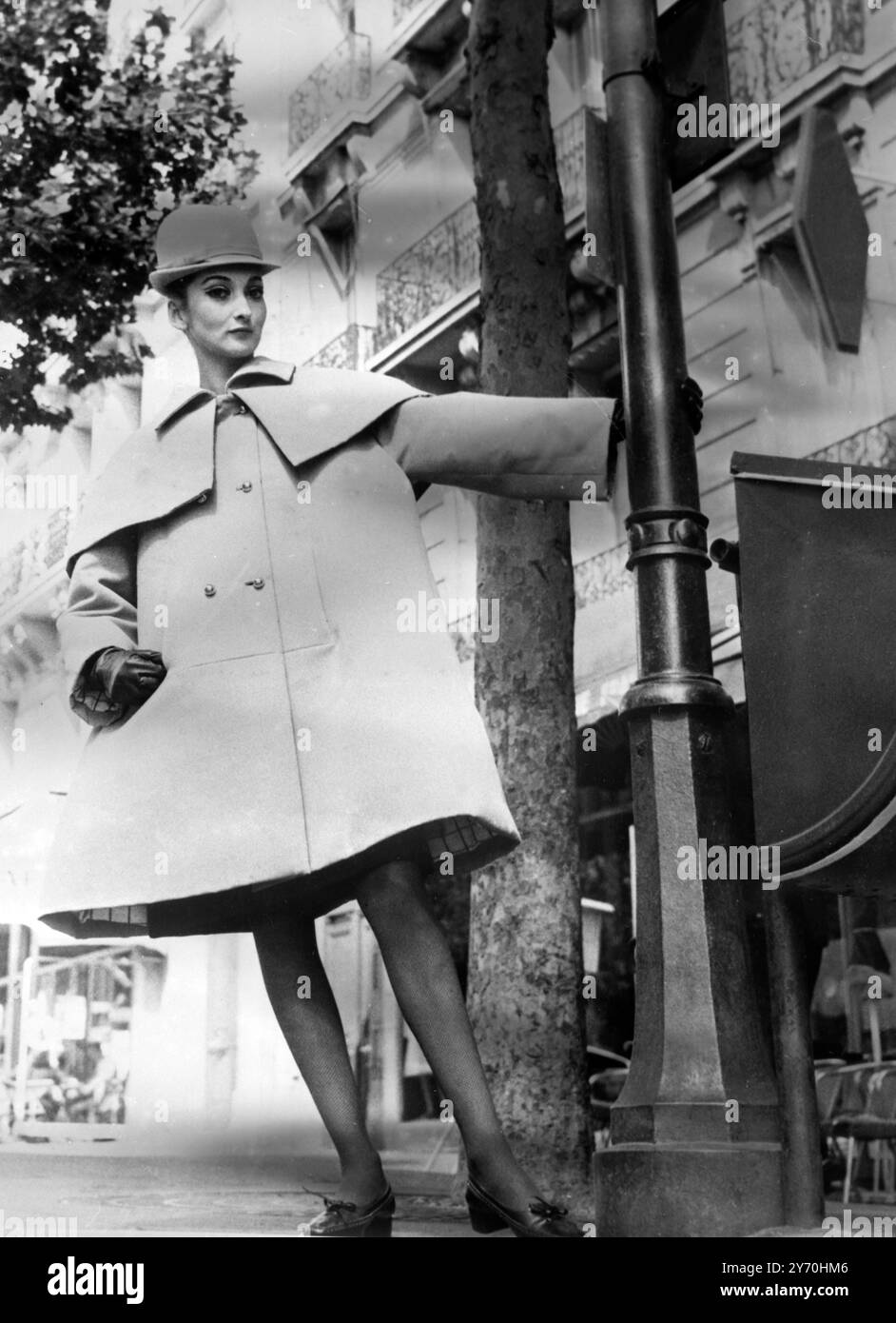 Parigi : il ritorno del cappotto più ampio è mostrato in questo spettacolare cappotto da coachman creato da Hubert de Givenchy per la sua Winter Collection 1966 / 67 esposto a Parigi . Realizzata in morbido cashmere marrone caramello, presenta una mantello circolare corto con piccolo colletto per la preparazione della camera e una doppia fila di bottoni dorati. Cappello femminilizzato in feltro perfettamente coordinato con tubo a fantasia e scarpe con tacco piatto sono marrone scuro per contrasto . 31 agosto 1966 Foto Stock