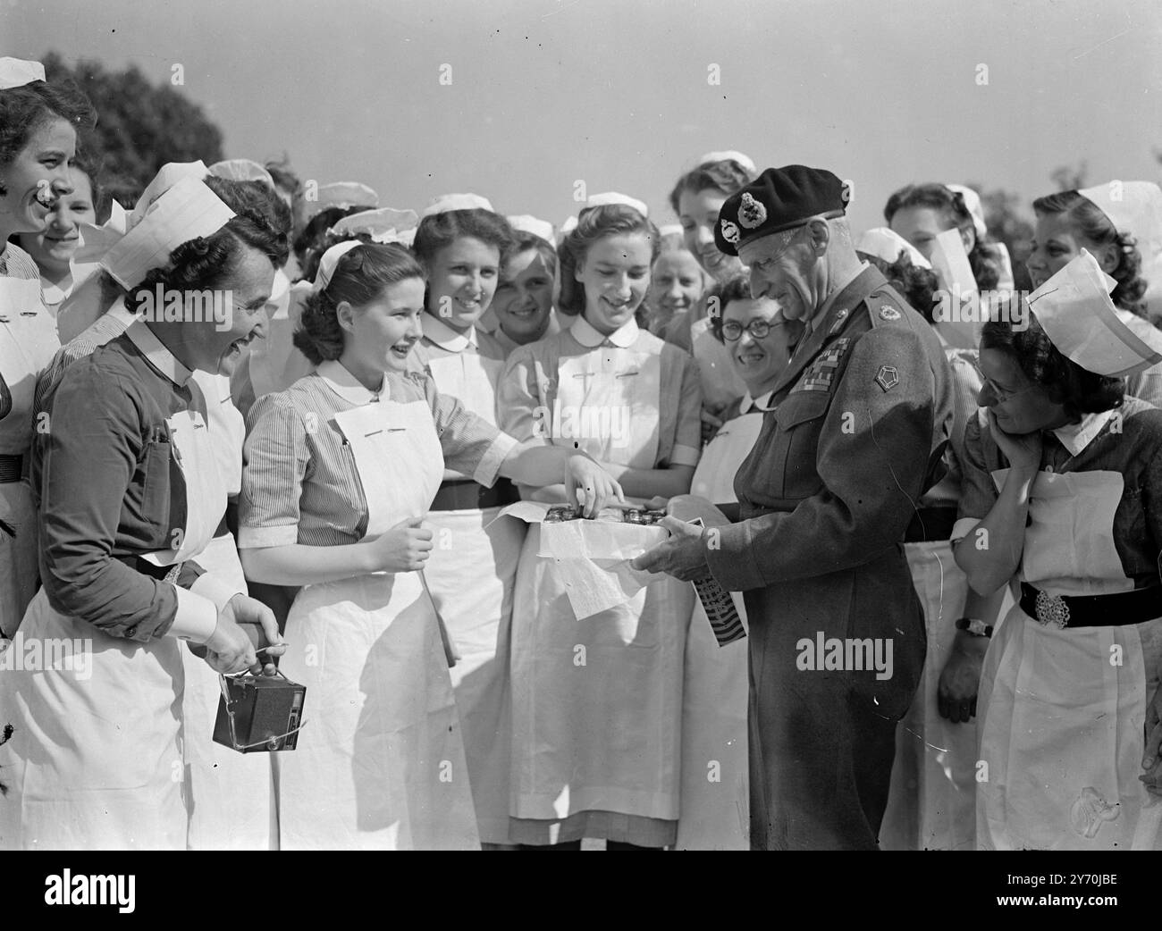 ' MONTY' LI CONSEGNA INTORNO e' un caso di caduta' quando il feldmaresciallo visconte Montgomery, comandante in capo della Western Union, offre a queste infermiere una scatola di cioccolatini che, secondo lui, era la piu' grande che potesse trovare nell' Europa occidentale. Monty, che stava aprendo una nuova casa per infermieri a Langley Avenue, Surbiton, Surrey, ricordava che la sua stessa vita era stata salvata (da infermieri qualificati dopo essere stato ferito nella prima guerra mondiale). Per esprimere la sua gratitudine era necessaria una grande scatola di cioccolatini . Vista prendere un cioccolato è una ragazza gallese , infermiere BRENDA JENKINS . L'hom Foto Stock