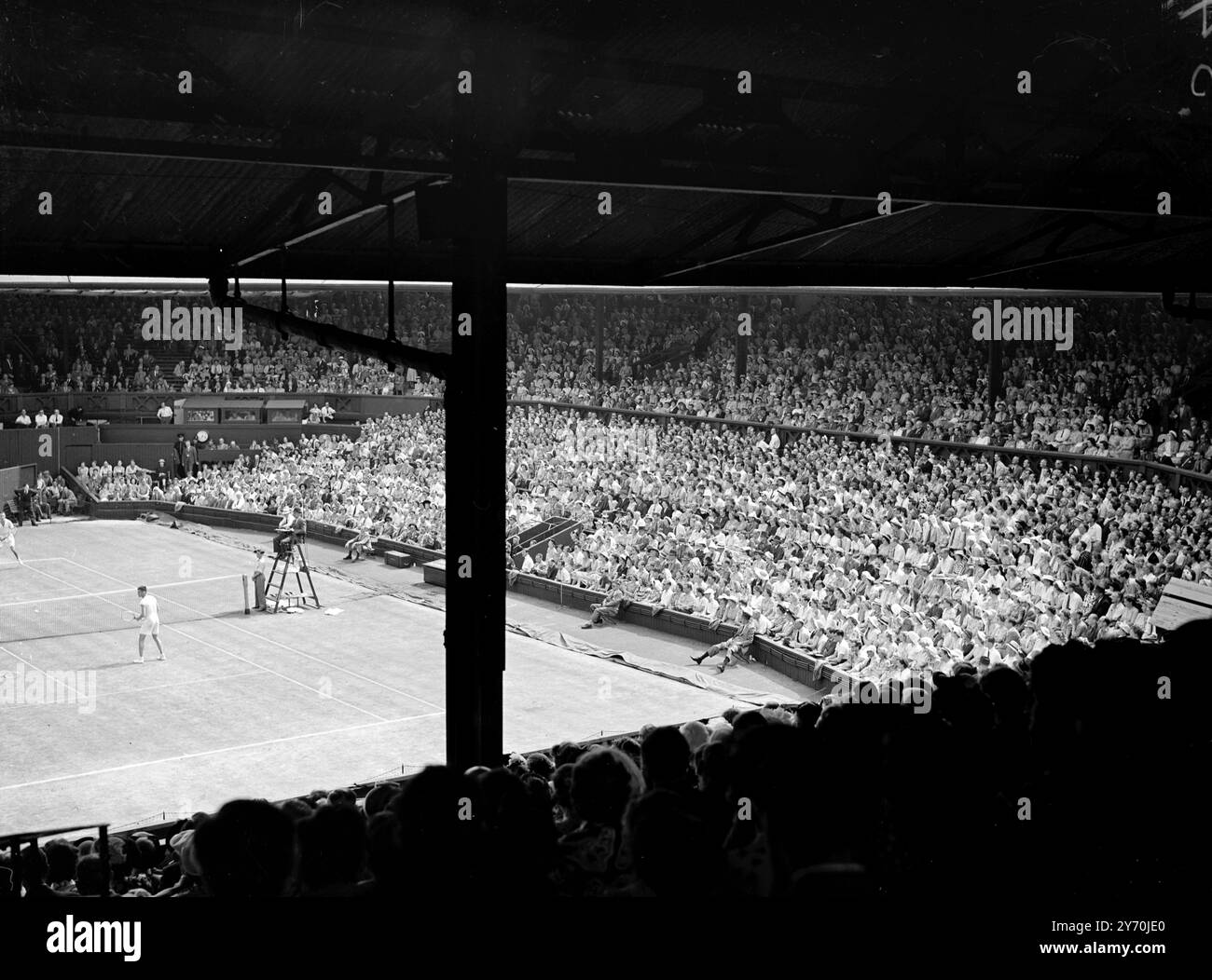 IL TEMPIO DEL TENNIS per gli appassionati di tennis di tutto il mondo , questo è il panorama più emozionante del mondo , al centro delle loro ambizioni , l' ispirazione della loro diligenza sui campi locali . E' il Centre Court presso l'All-England Club, Wimbledon, durante i campionati di tennis sul prato. Il campo illuminato dal sole e i gradini di posti a sedere pieni di spettatori creano un'atmosfera della "grande occasione" non esattamente imitata in nessun altro centro di tennis internazionale. Questa foto è stata scattata durante gli attuali campionati quando A.J. MOTTRAM ( a sinistra ) e GEOFFREY PAISH di Gran Bretagna -o Foto Stock