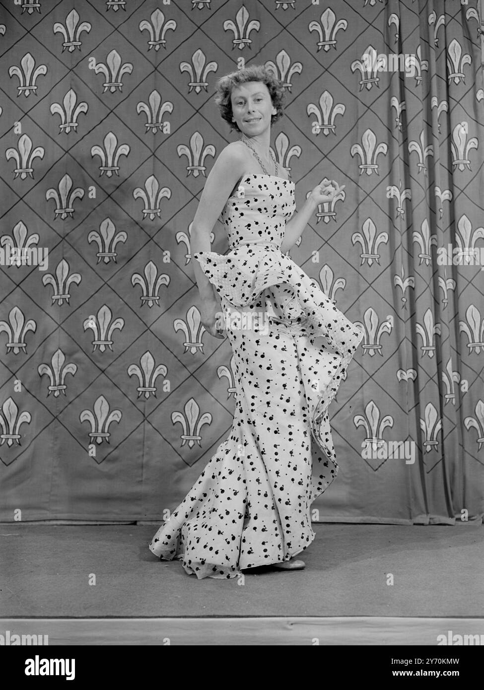 MODA PARIGINA IN SFILATA DA TELEVIEWERS INGLESI nuove mode primaverili ed estive portate in particolare da Parigi e modellate da manichini francesi sono presenti in un programma televisivo di Alexandra Palace ( Londra ) . Le creazioni provengono da designer di fama mondiale come Balmain , Faith , Molyneux , Piguet e Schiaparelli , e gli spettatori possono confrontarle con le mode britanniche recentemente trasmesse in televisione . FOTO MOSTRA :- Un abito da cocktail bianco organdie con abito da cocktail nero organdie con macchie ricamate nere e un baldacchino a spirale davanti modellato su un Alexandra Place riascolta Foto Stock