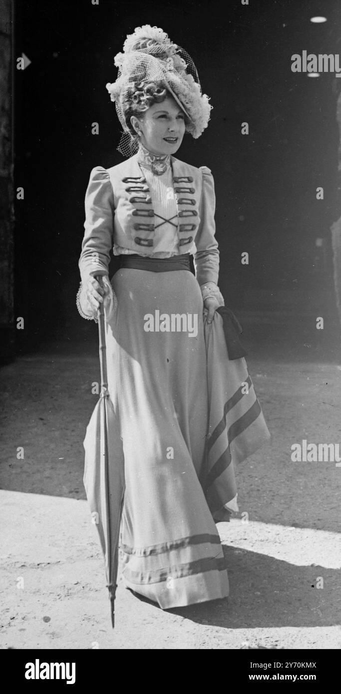 LUNGOMETRAGGIO completo questo costume d'epoca è indossato dall'attrice scozzese EILEEN HERLIE , che appare qui nel ruolo di Henrietta Alt nella produzione cinematografica londinese The Angel with the Trumpet . Il cappello e' di paglia color pesca con sontuose rifiniture di piume di struzzo in blu pallido e pesca . 23 aprile 1949 Foto Stock