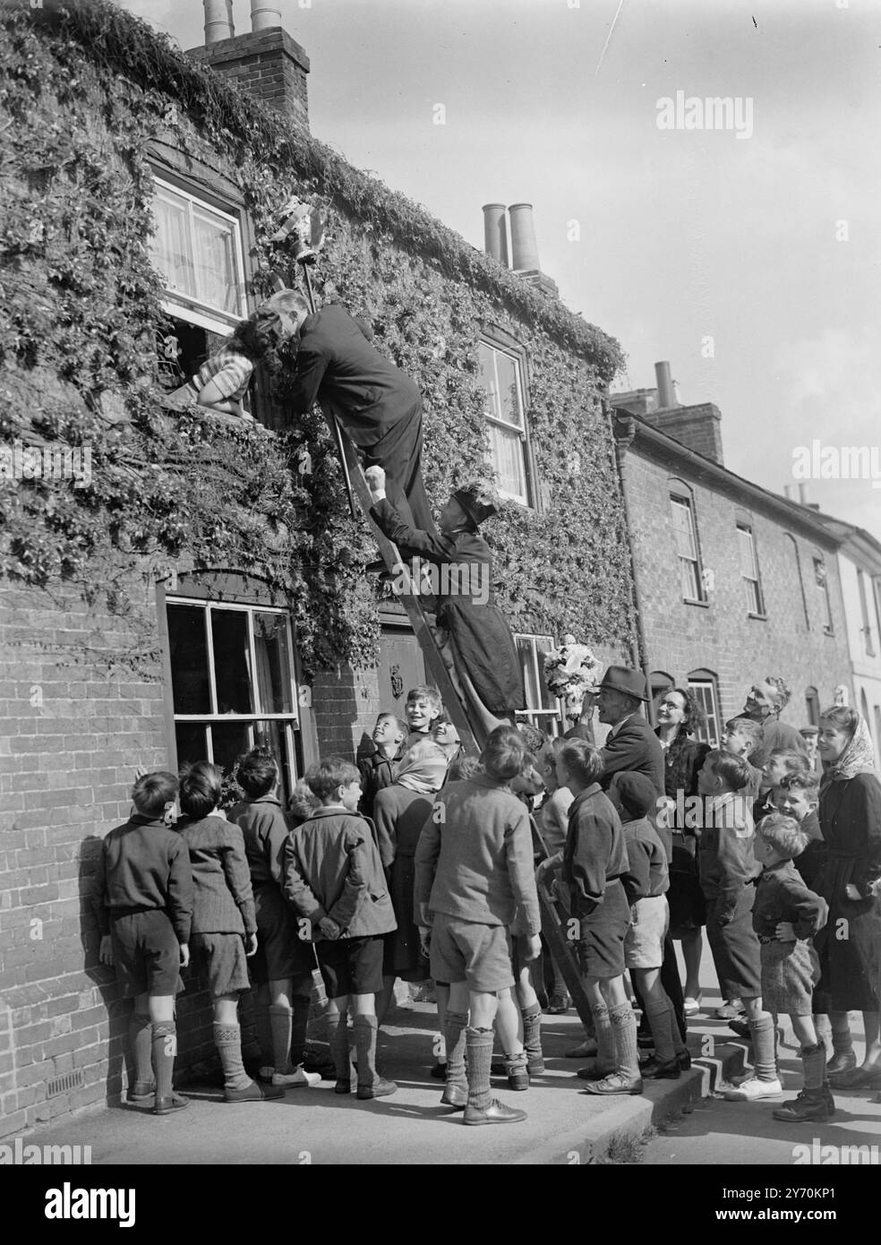 TUTTI-MAN, IN SCALA, SOSTIENE IL SUO BACIO il diritto di baciare le ragazze più belle della città fu rivendicato dai tutti (o titipizzazione) uomini di Hungerford, Berkshire, quando vi ebbe inizio l'annuale festa dell'Hocktide. Dopo che la corte di Hocktide aveva eletto tutti, gli uomini venivano date le tradizionali bacchette d'ufficio, le stalle decorate con fiori. Essi esercitarono quindi il privilegio di raccogliere un centesimo da ogni residente o di baciare la ragazza più bella sul posto. Le celebrazioni commemorano la concessione di diritti di pesca libera e di terra comune da parte di Giovanni di Gaunt 600 anni fa . Foto Stock