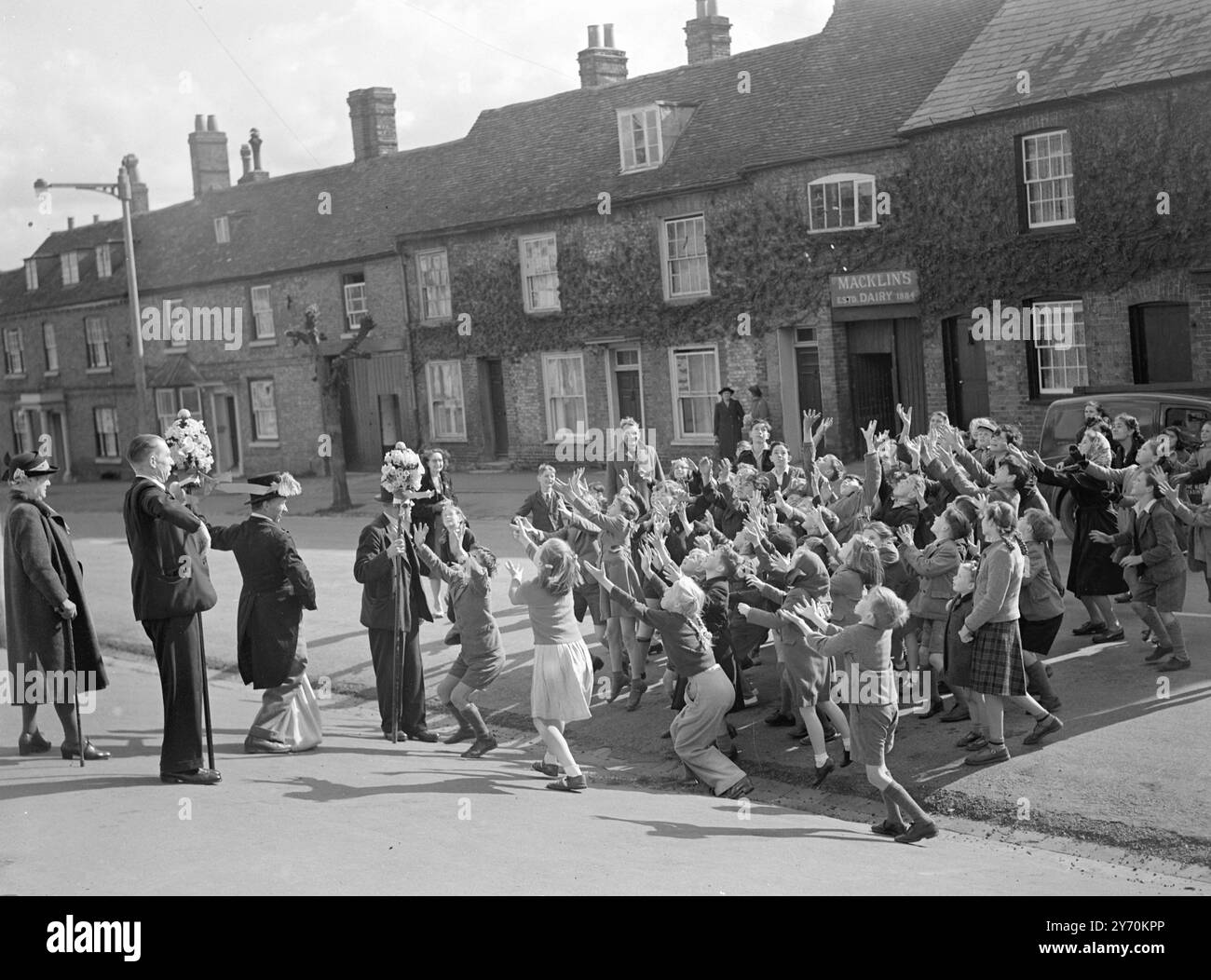 TUTTI-MAN, IN SCALA, SOSTIENE IL SUO BACIO il diritto di baciare le ragazze più belle della città fu rivendicato dai tutti (o titipizzazione) uomini di Hungerford, Berkshire, quando vi ebbe inizio l'annuale festa dell'Hocktide. Dopo che la corte di Hocktide aveva eletto tutti, gli uomini venivano date le tradizionali bacchette d'ufficio, le stalle decorate con fiori. Essi esercitarono quindi il privilegio di raccogliere un centesimo da ogni residente o di baciare la ragazza più bella sul posto. Le celebrazioni commemorano la concessione di diritti di pesca libera e di terra comune da parte di Giovanni di Gaunt 600 anni fa . Foto Stock