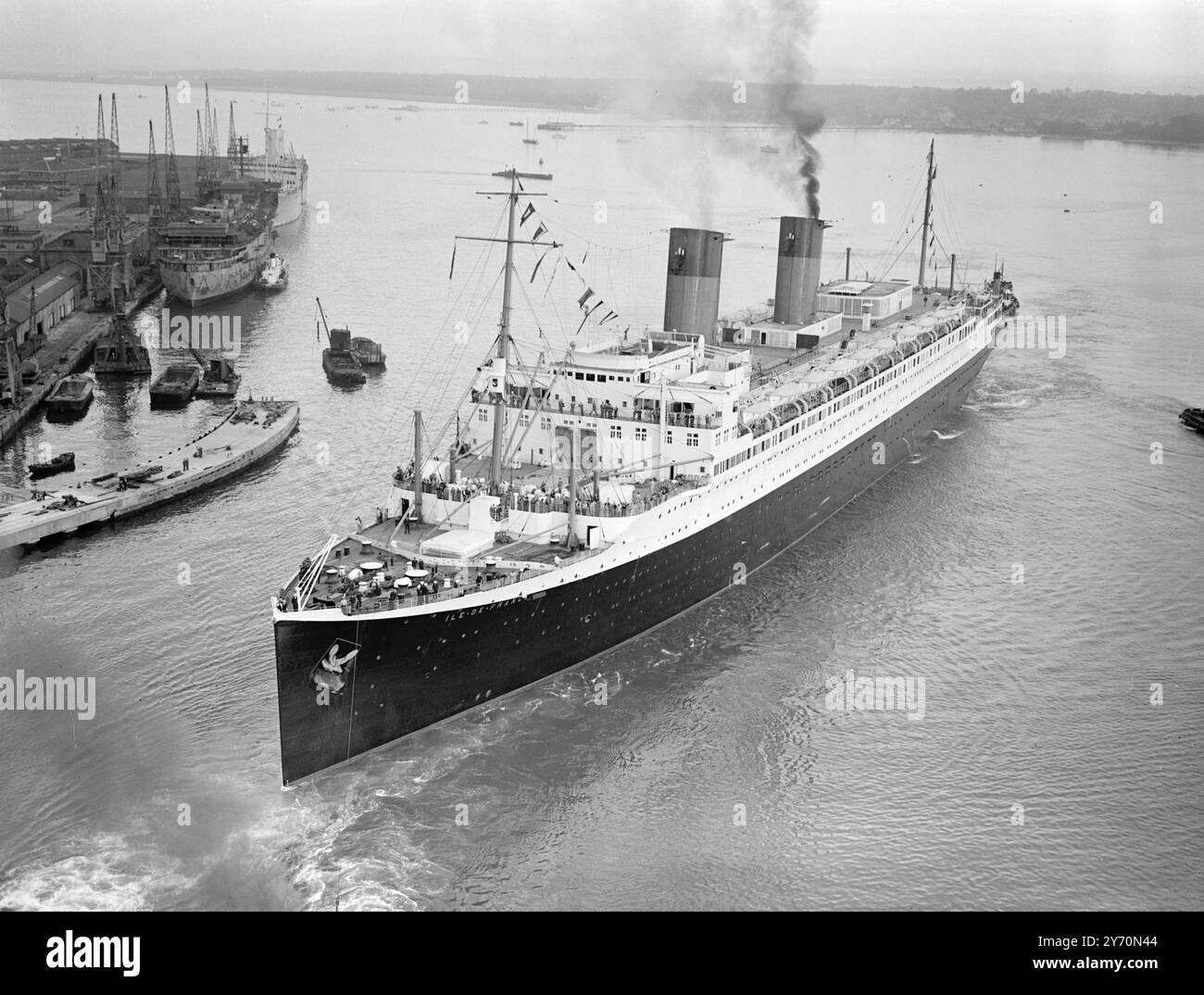 DI NUOVO IN SERVIZIO la lixery liner francese ILE DE FRANCE , quarta più grande al mondo , oggi rientrò nel servizio passeggeri transatlantico , in cui gareggerà con la Regina Maria e la Regina Elisabetta . Dopo aver servito come nave da truppa britannica durante la guerra , è stata completamente ricostruita nel suo scafo originale. LE IMMAGINI MOSTRANO:- Tugs che scortano l'ILE DE FRANCE a Southampton la scorsa notte. 21 luglio 1949 Foto Stock