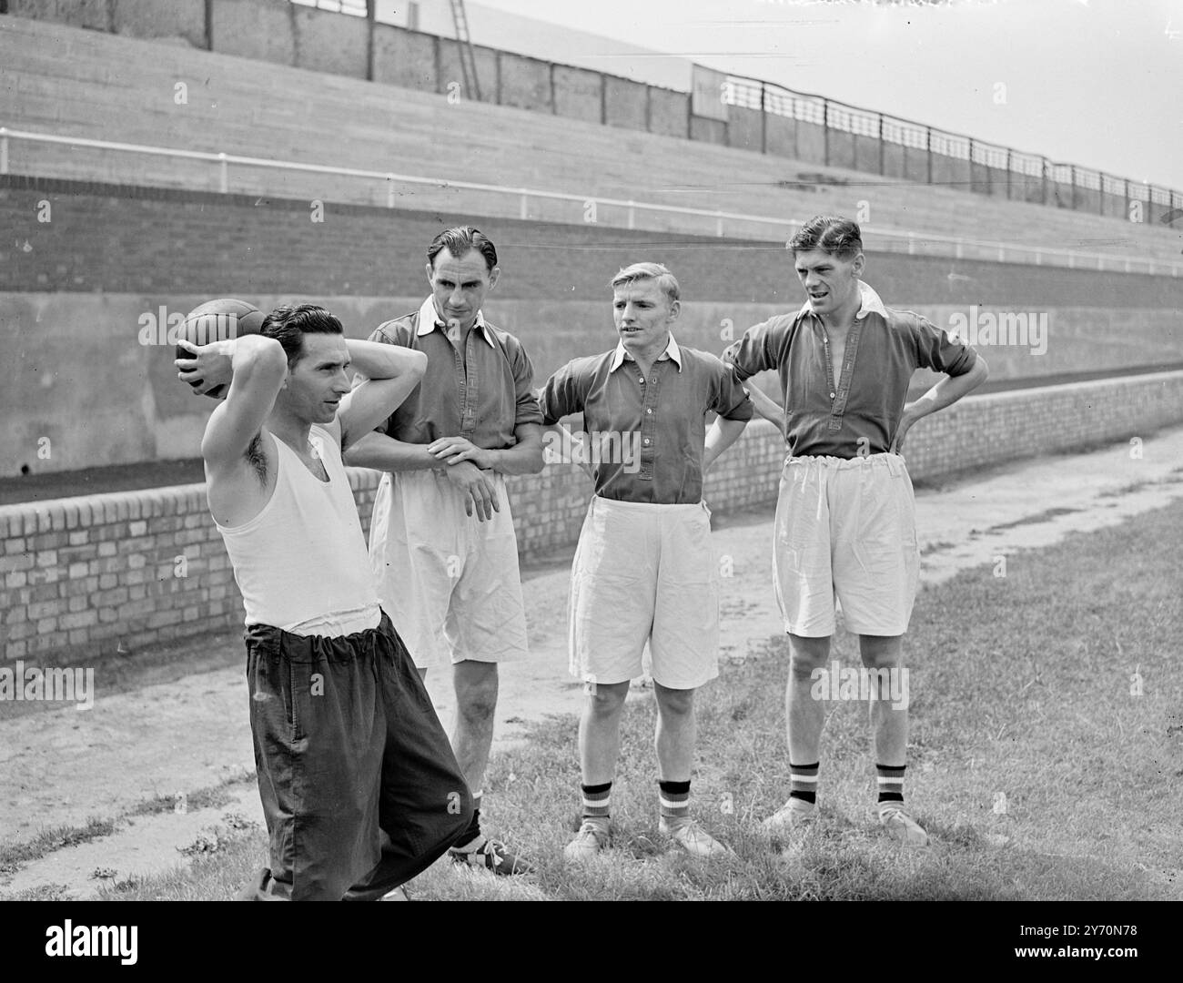 MILLWALL PRENDE IL ' CAMPO ' PER LA NUOVA STAGIONE SAM WEAVER , ex Inghilterra , Chelsea e Newcastle metà ala che era noto per il suo lungo lancio ( poteva lanciare la palla dal touchline al goalmouth ) rivela i segreti - da sinistra a destra - G. BRADLEY , S. MYERS e F. REEVES , Mill Wall Wing Halves , quando i giocatori del Millwall iniziarono ad allenarsi per la prossima stagione calcistica al Den , New Cross , Londra . Sam Weaver ha appena assunto il suo nuovo incarico di allenatore del Millwall . Luglio 25 1949 Foto Stock