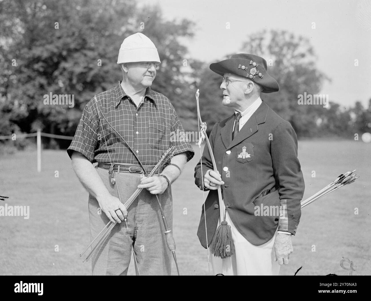 ABITI PER ARCHERS nuove note nei copricapo da uomo sono colpite dal Dr. Roberts e .P.Elma, di Wayne, Pennsylvania U.S.A (a sinistra), e Mr. W. Melville Foster, di Cheltenham (Gloucestershire). Stanno gareggiando ai Campionati nazionali di tiro con l'arco al Worcester College di Oxford, questa settimana. Vi partecipano quasi 100 arcieri, con uomini e donne in numero approssimativamente uguale. 20 luglio 1949 Foto Stock