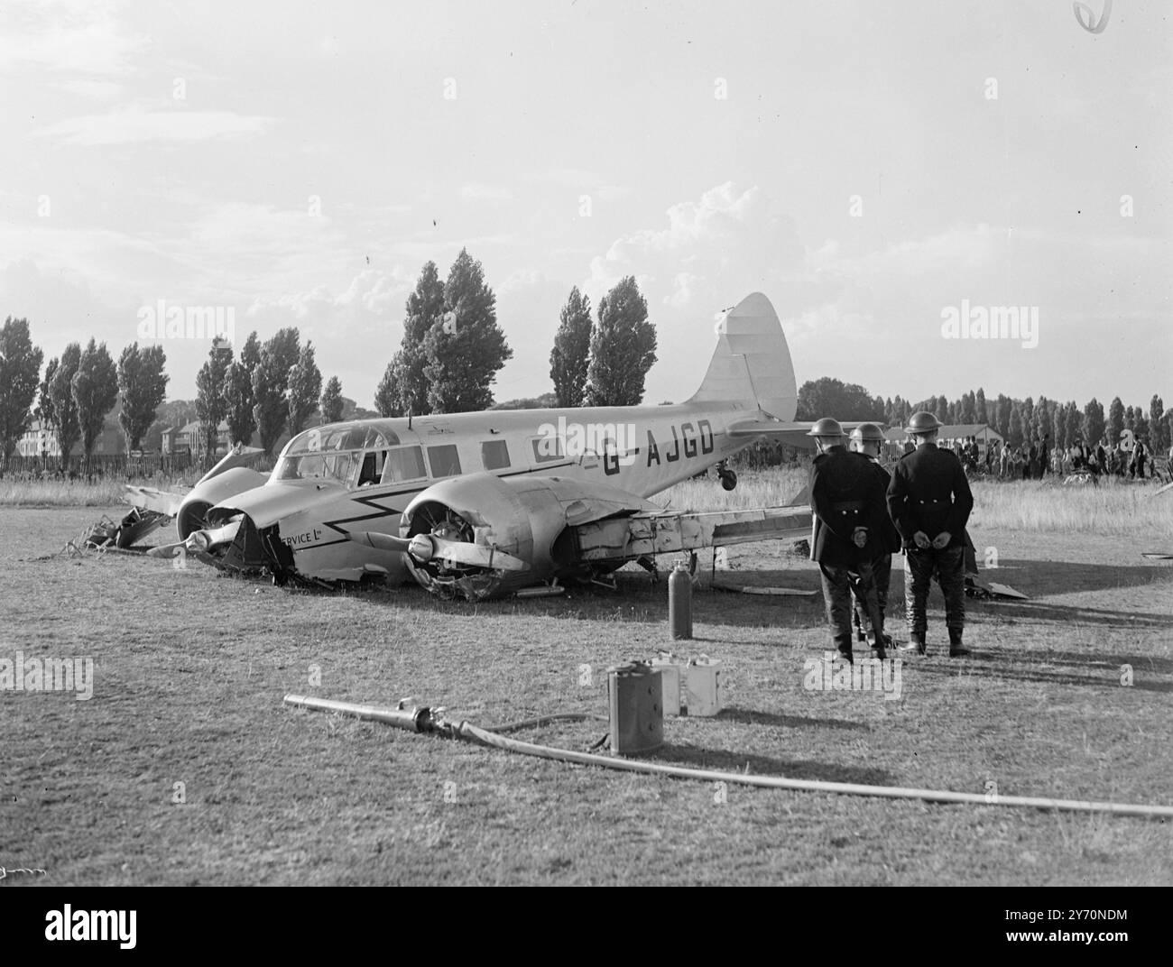 'L'AEREO FA ATTERRAGGIO FORZATO SUL CAMPO SPORTIVO Di LONDRA Un aereo bimotore a console da sei piedi ha effettuato un atterraggio forzato sul campo dei club sportivi del servizio civile vicino a Dukes Meadows Chiswick, Londra. Prima di fermarsi, l'aereo si è schiantato attraverso la recinzione che ha spogliato parti della fusoliera e le ha sparse in giro, ma né il pilota né il passeggero sono stati feriti. I N.F.S sono stati chiamati sulla scena, ma non c'e' stato nessun incendio. L'IMMAGINE MOSTRA: L'aereo danneggiato sul campo sportivo, con vigile del fuoco in attesa con le manichette scendono in caso di incendio. 15 luglio 1949 Foto Stock