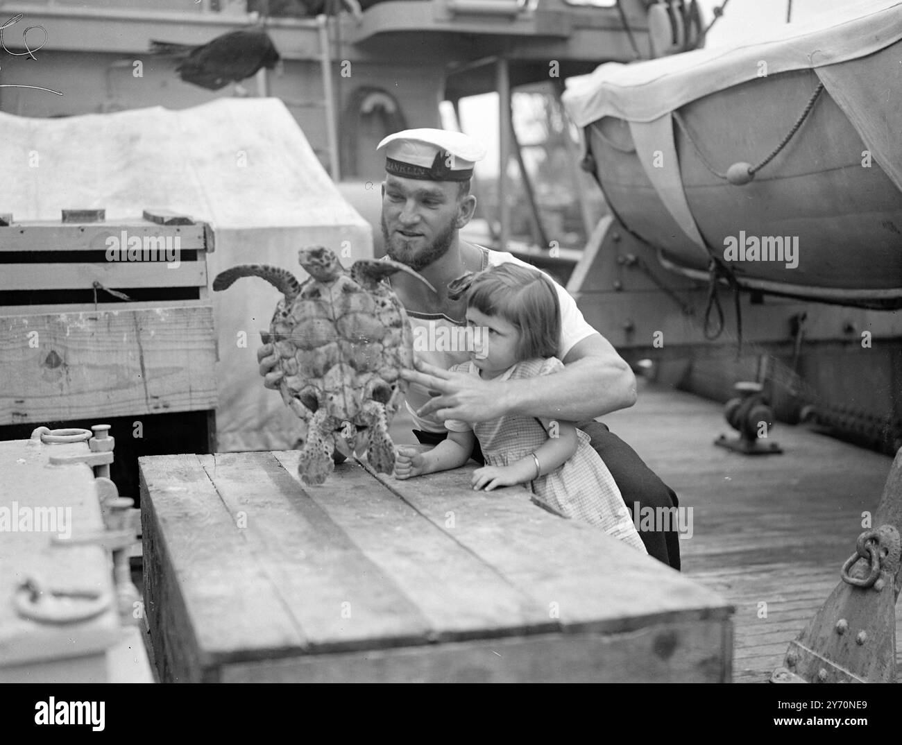 100 SIGARETTE - UNA TARTARUGA acquistata per 100 sigarette nelle isole di Capo Verde, questa tartaruga è un ''passeggero'' nella nave antartica ' John Biscoe ' - viene introdotta dal marinaio barbuto Donald Cassam di Sevenoaks, Kent, alla quindicenne Carol Johnston, figlia del capo della guardia forestale, a Southampton, dove il ' John Biscoe ' attraccò oggi, al suo ritorno a casa. L'acquirente della tartaruga era il dottor William J.L.Sladen di Esher, Surrey, che ha servito come ufficiale medico in Antartide e ora ha ricevuto la M.B.E. (divisione civile) l'eroismo in un incendio di base. T Foto Stock
